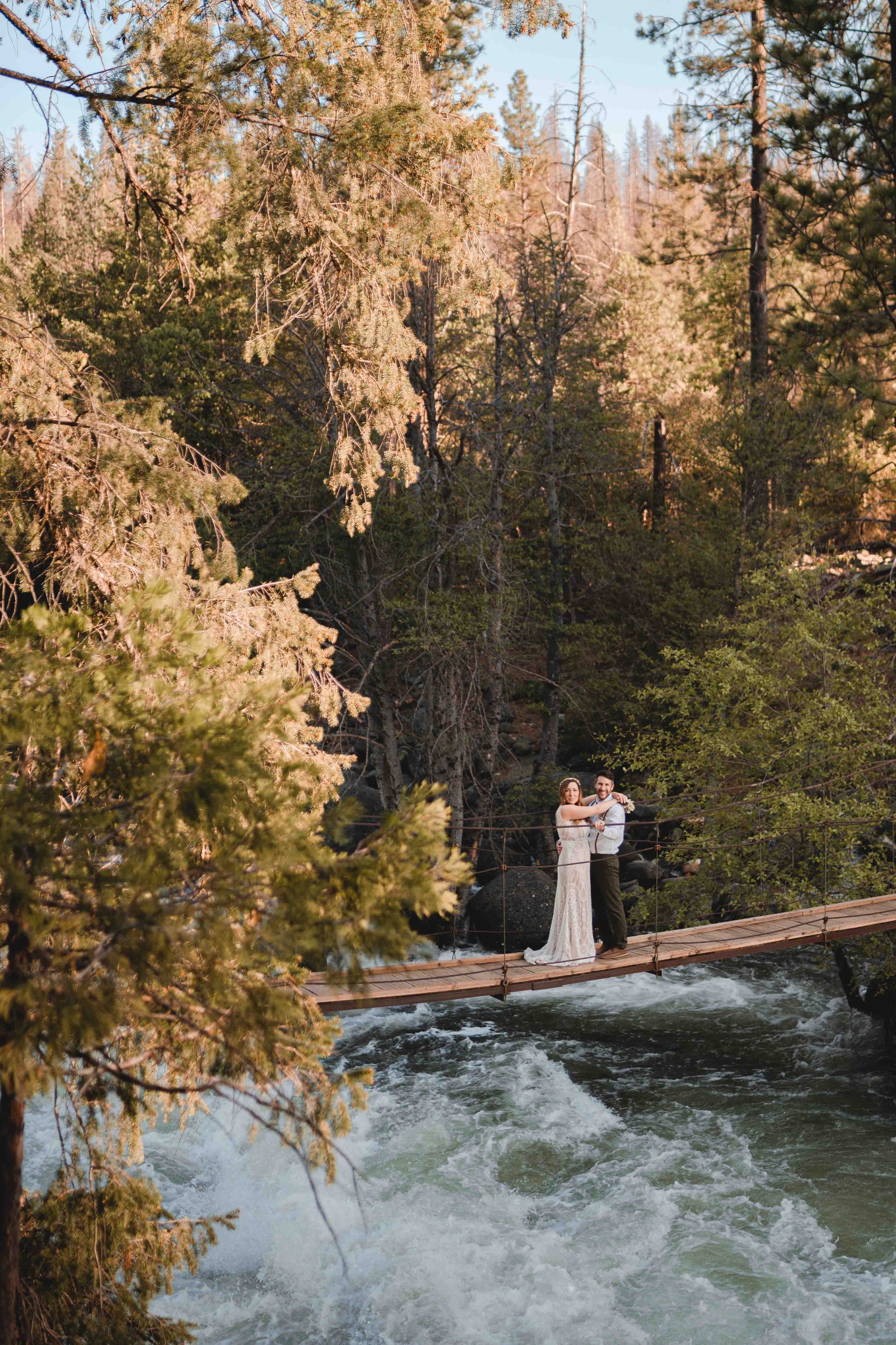 Newly weds standing on a bridge at sunset