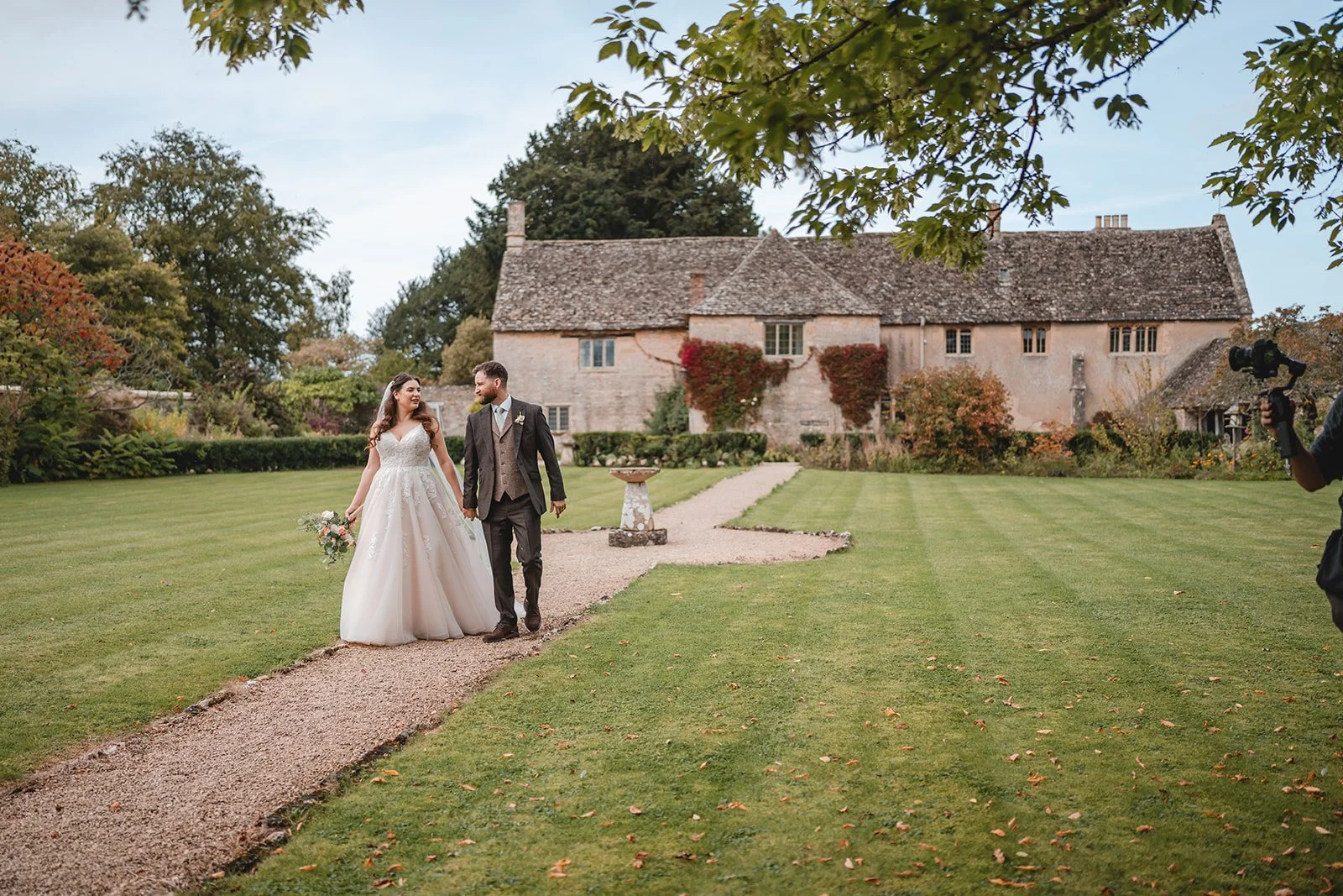 Sartis and Callum walking through countryside wedding venue