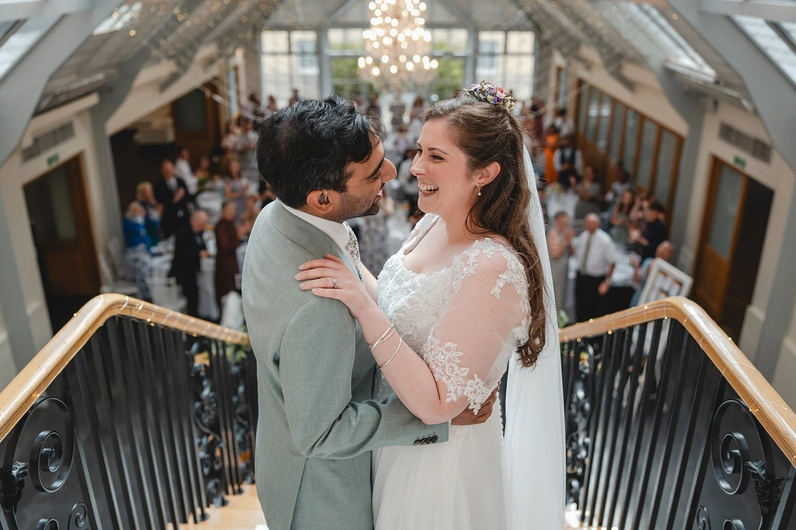 Dorothea and Peter laughing on staircase during wedding reception