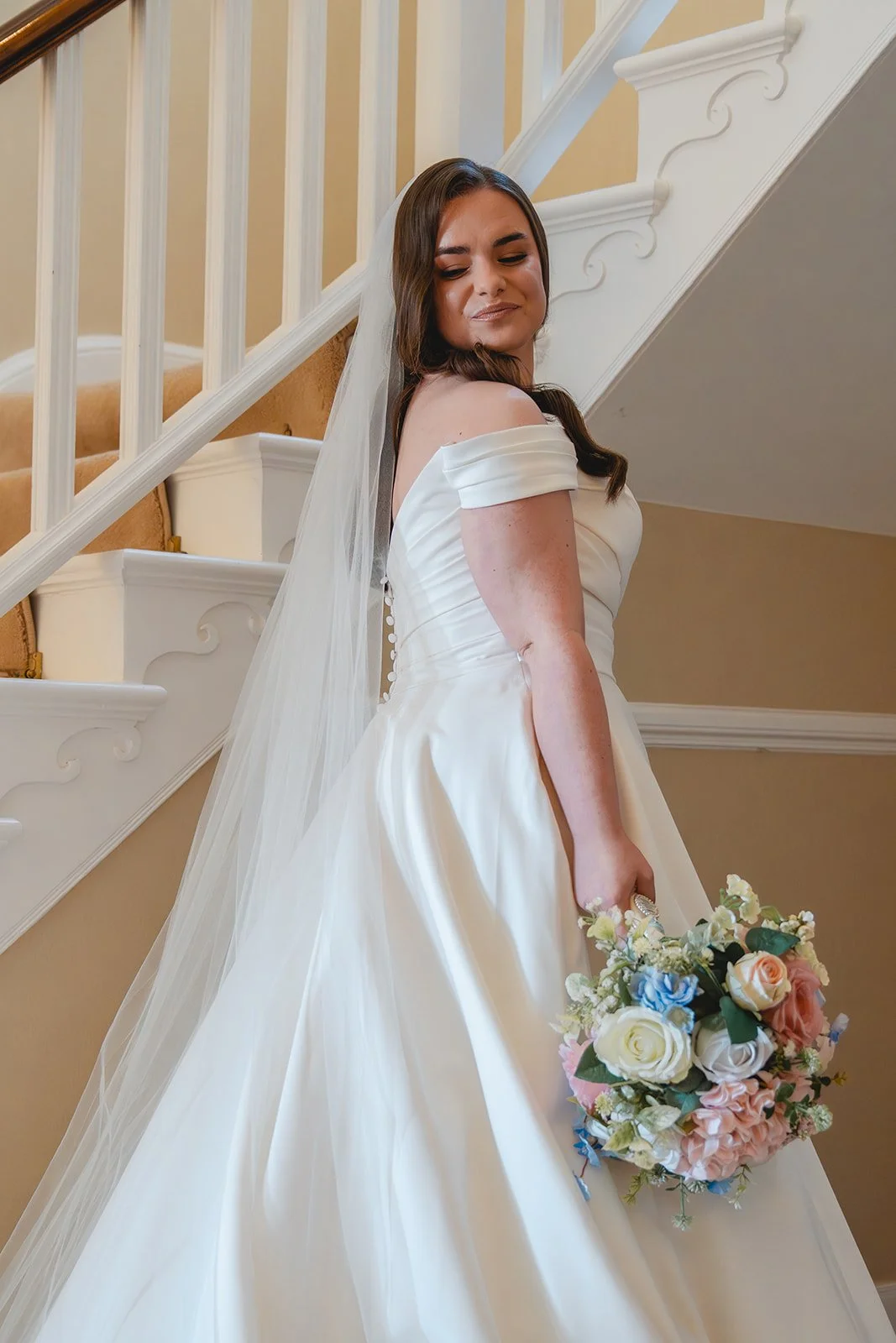 Shannon holding her wedding bouquet on the staircase