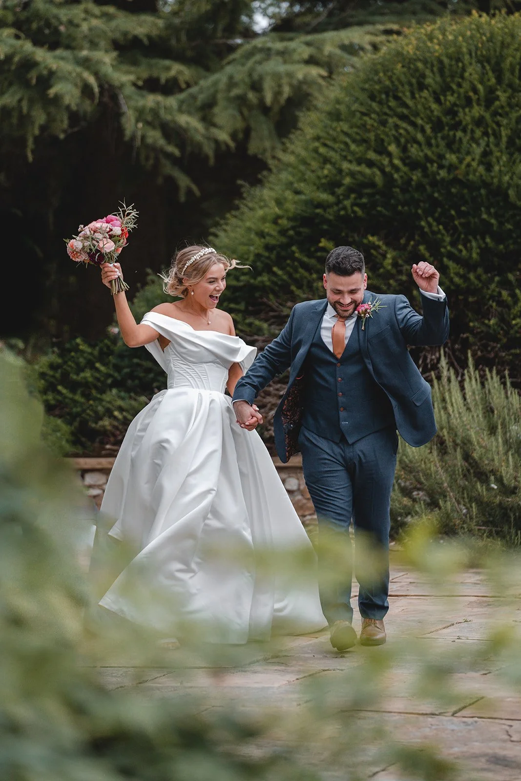 Chloe and Sina walking through wedding venue gardens