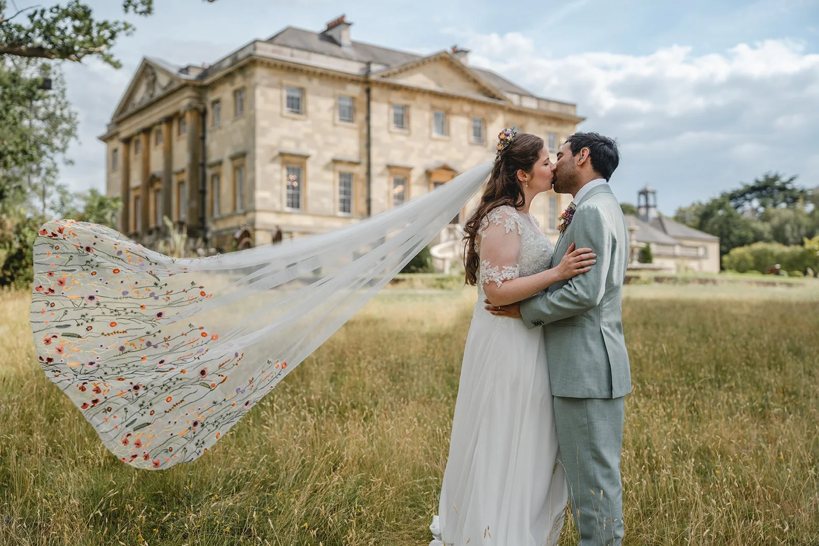 Dorothea and Peter kissing with bride's veil flowing