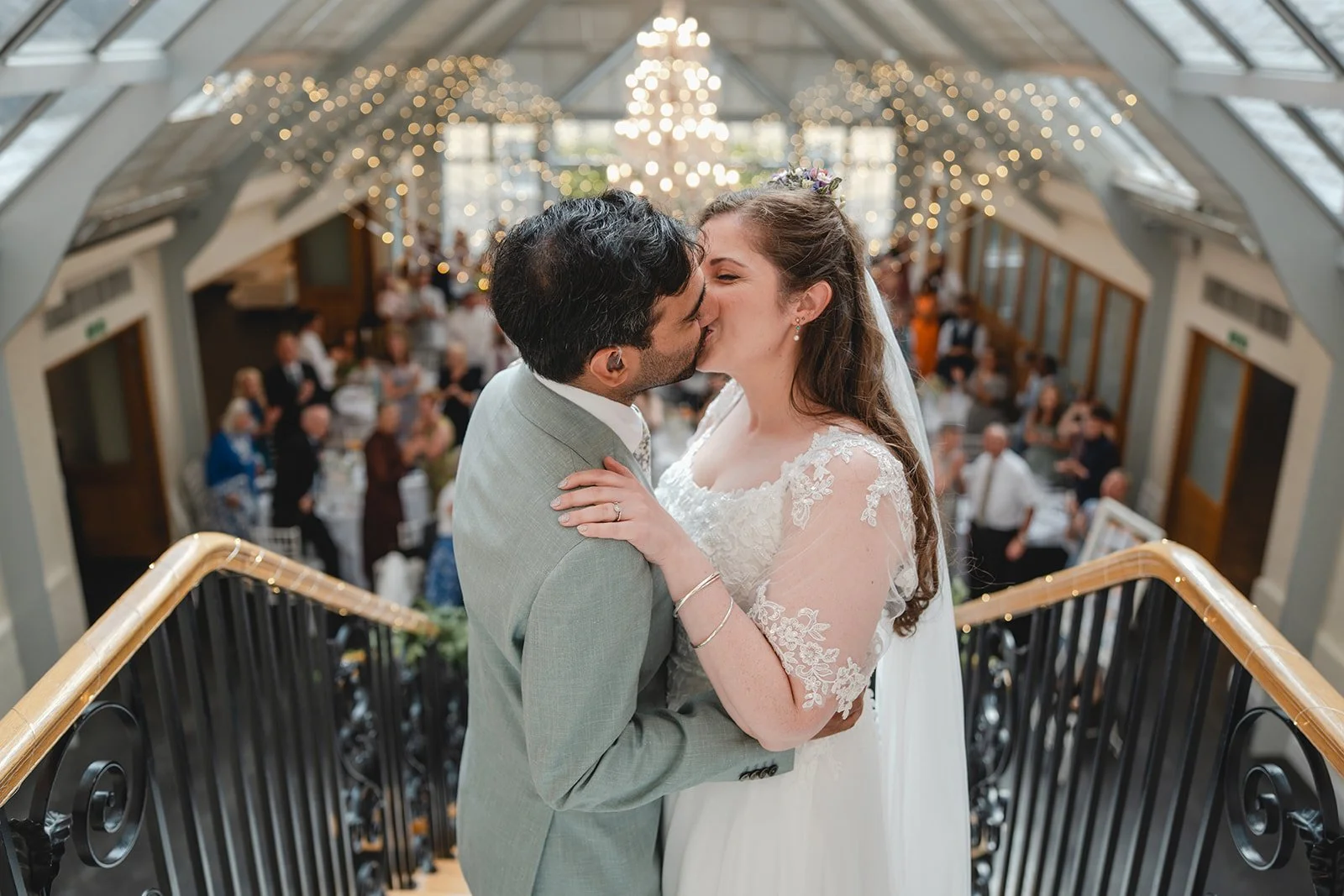 Dorothea and Peter kissing on staircase during wedding reception