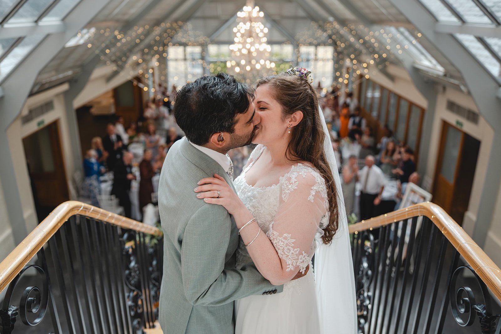 Dorothea and Peter kiss on staircase during reception