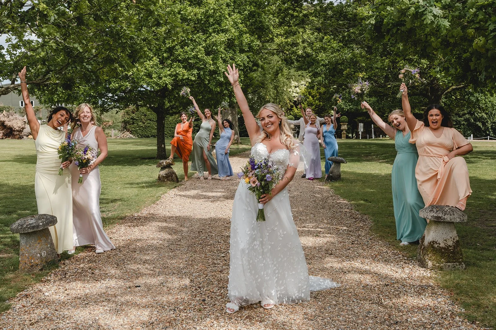 Abi with bridesmaids in colourful dresses outside the wedding venue