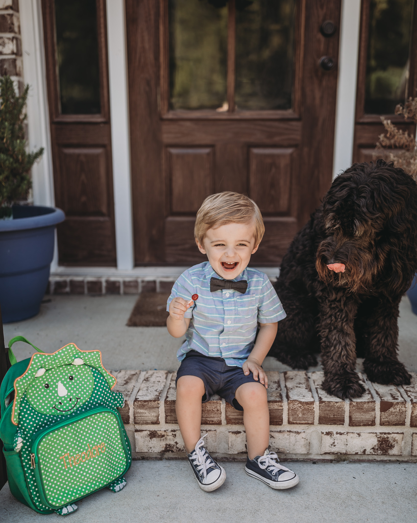 child with black goldendoodle 