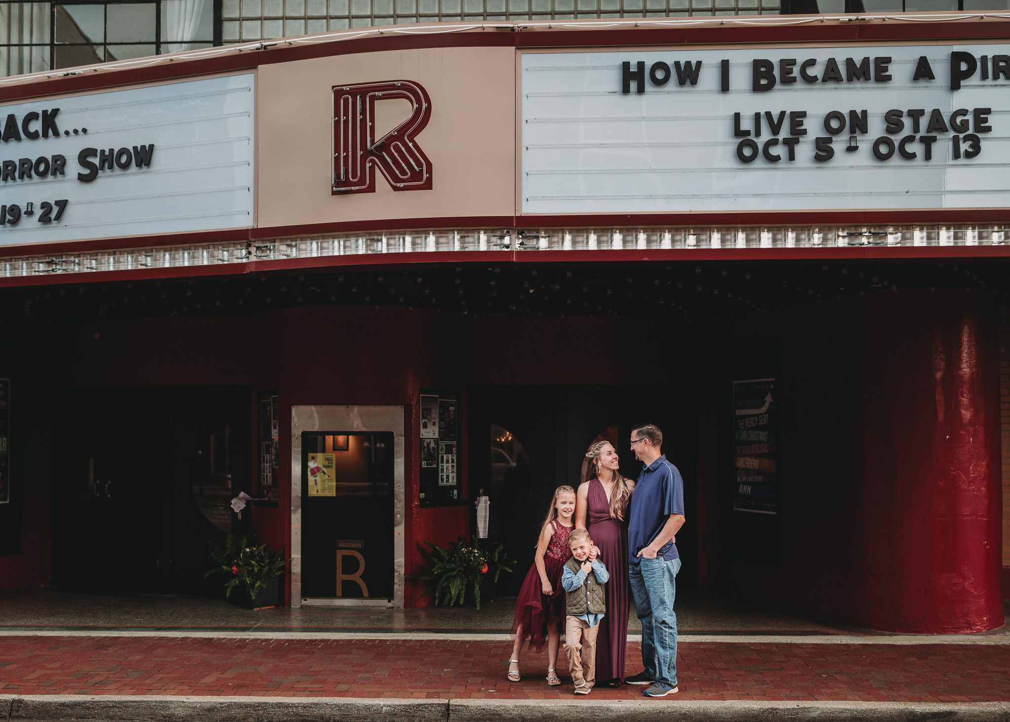 family pose in front of Roxy theater