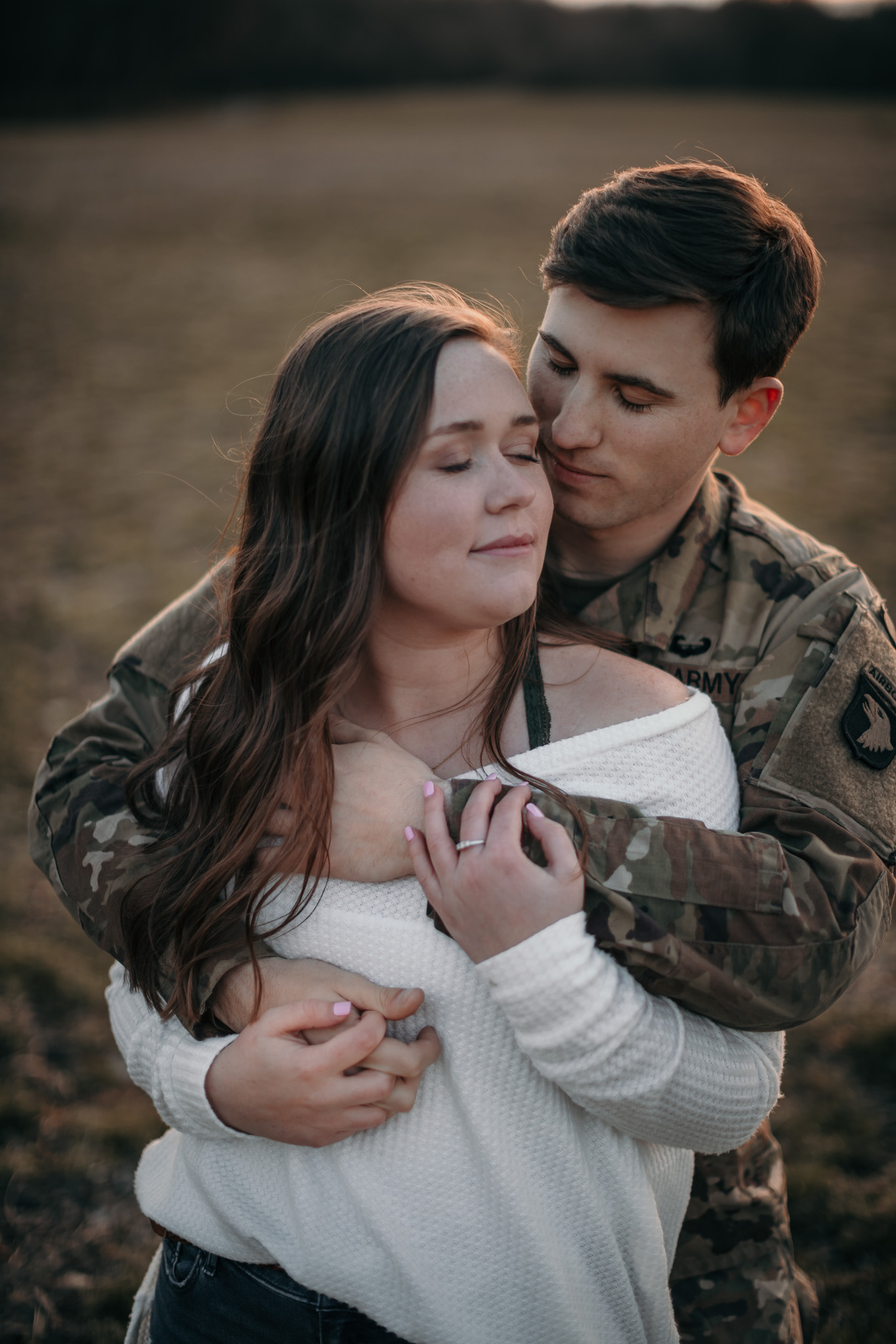 man in army uniform embracing girl