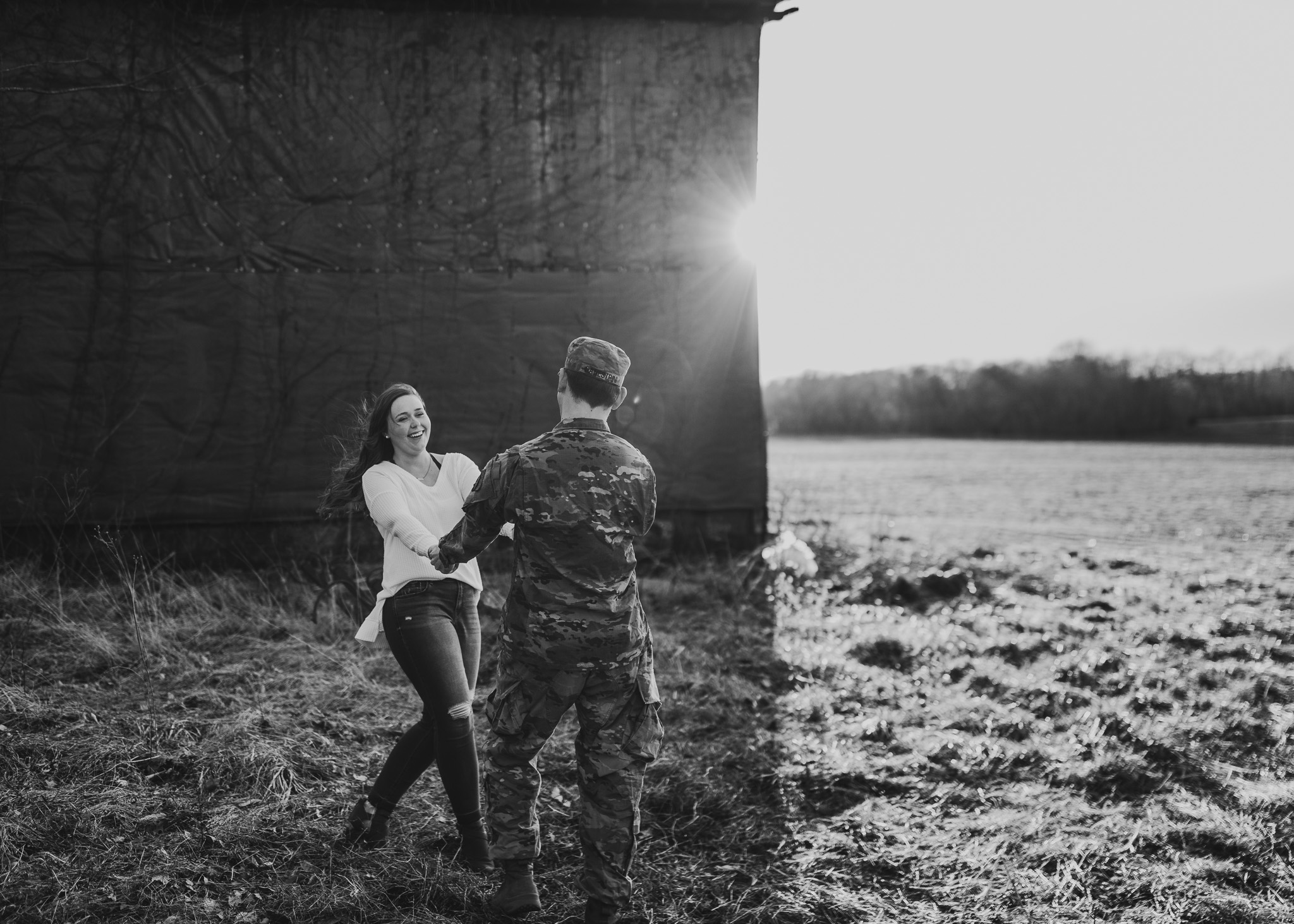 couple twirling in black and white and army uniform