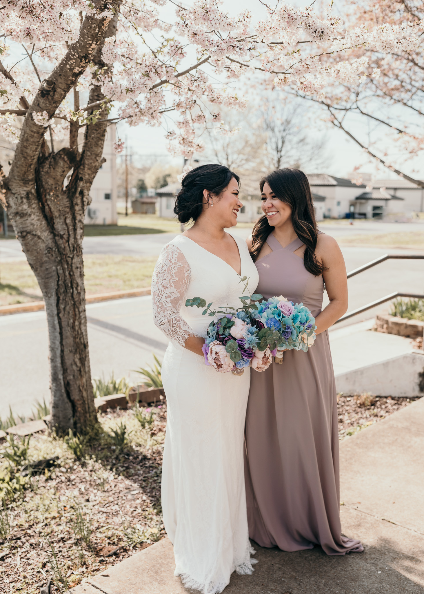 Bride and Bridesmaid Standing with Flowers