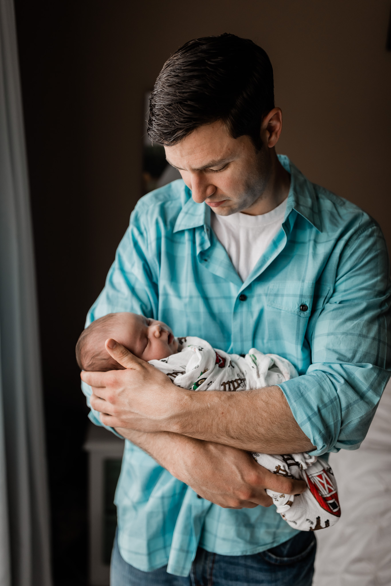 dad looking at newborn baby