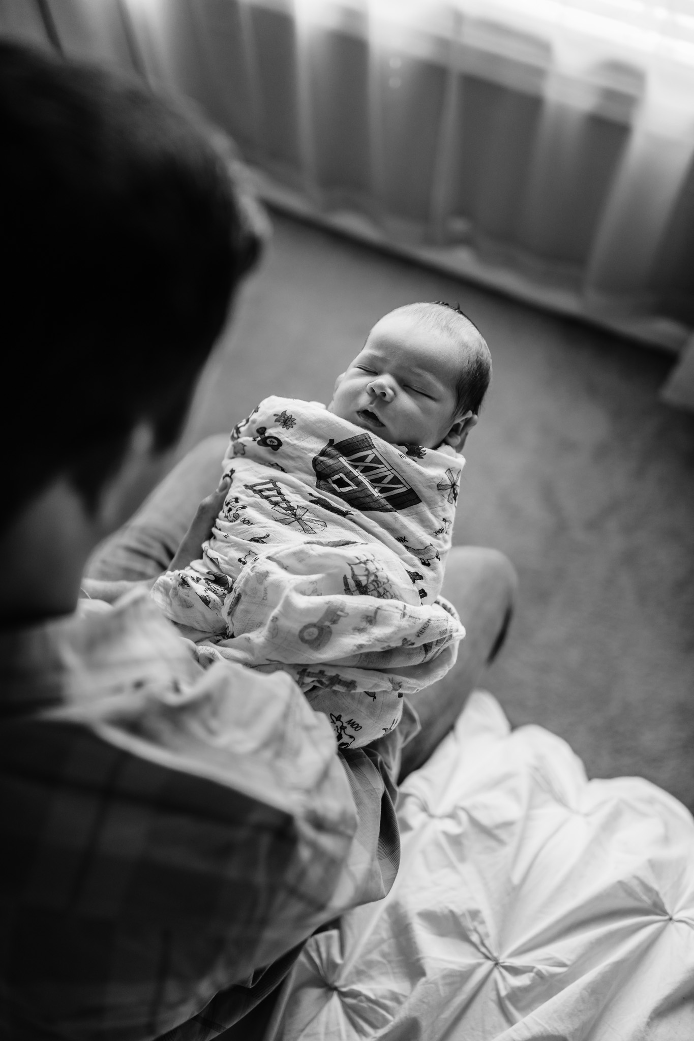 black and white of dad with newborn