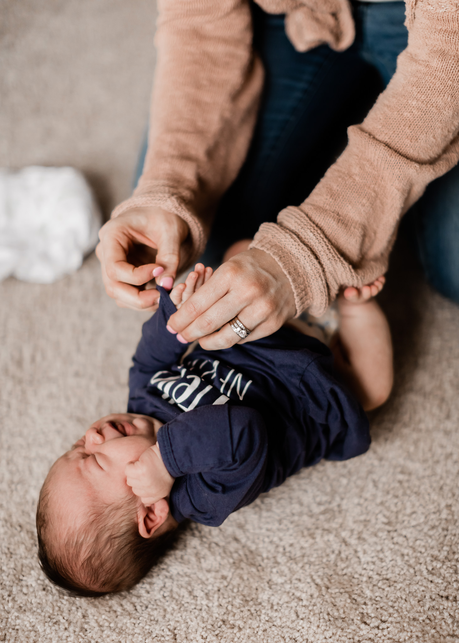 mom dressing newborn baby boy