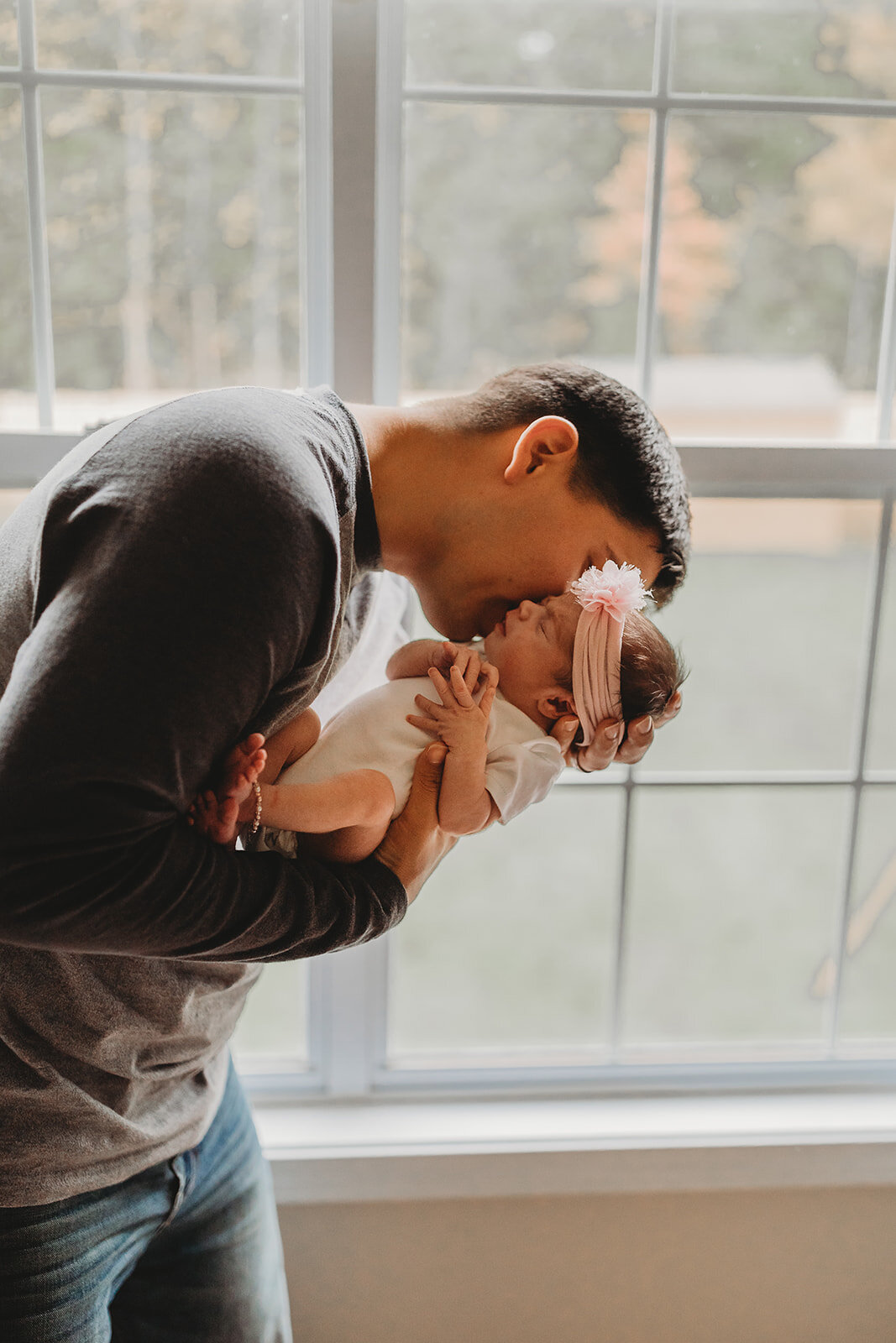 dad kissing newborn baby