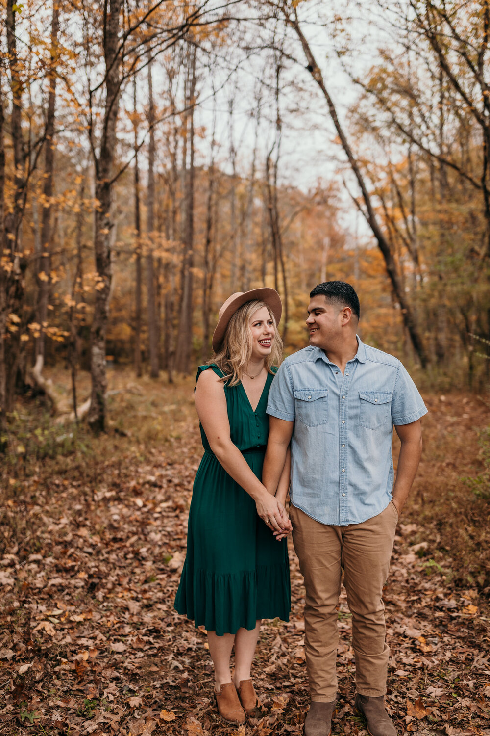 couple standing in trees at fall