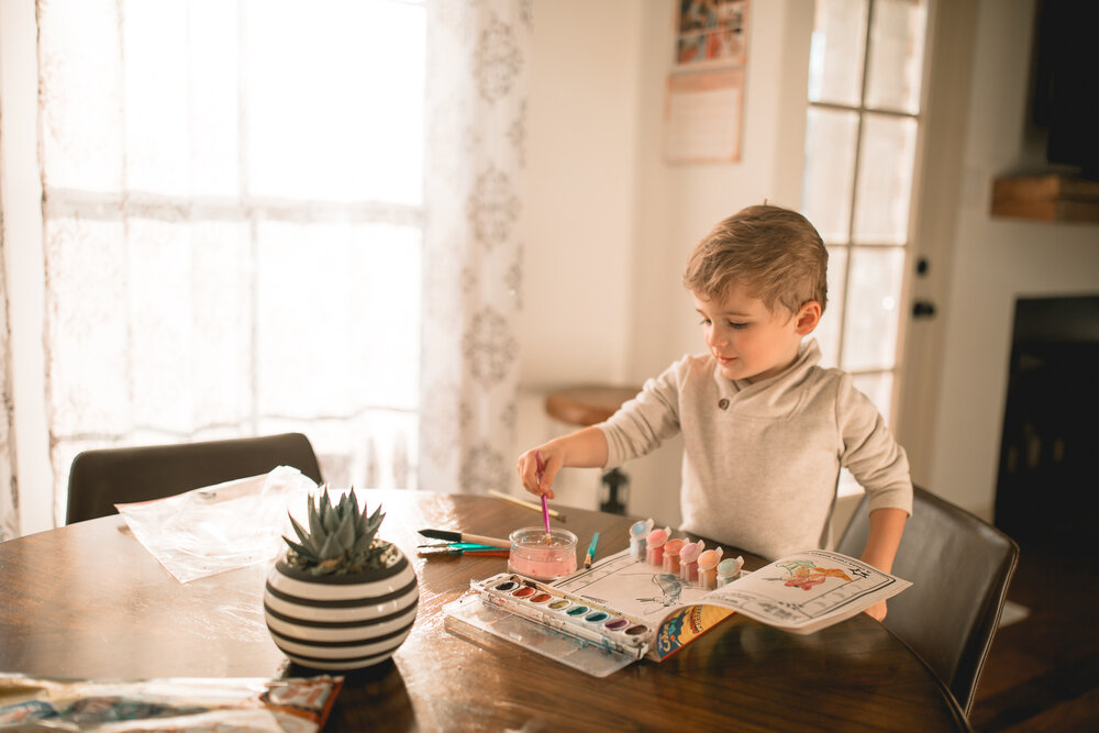 toddler painting in kitchen