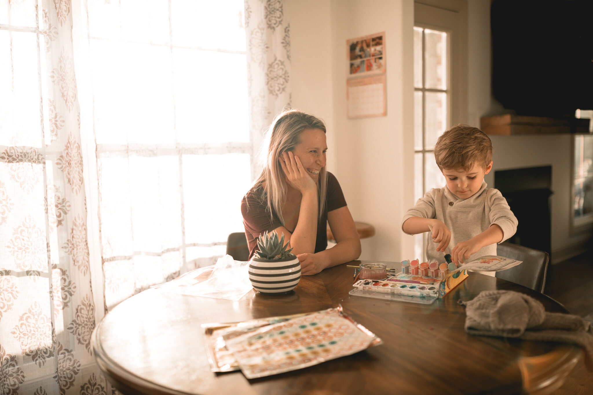 mom and toddler painting at kitchen