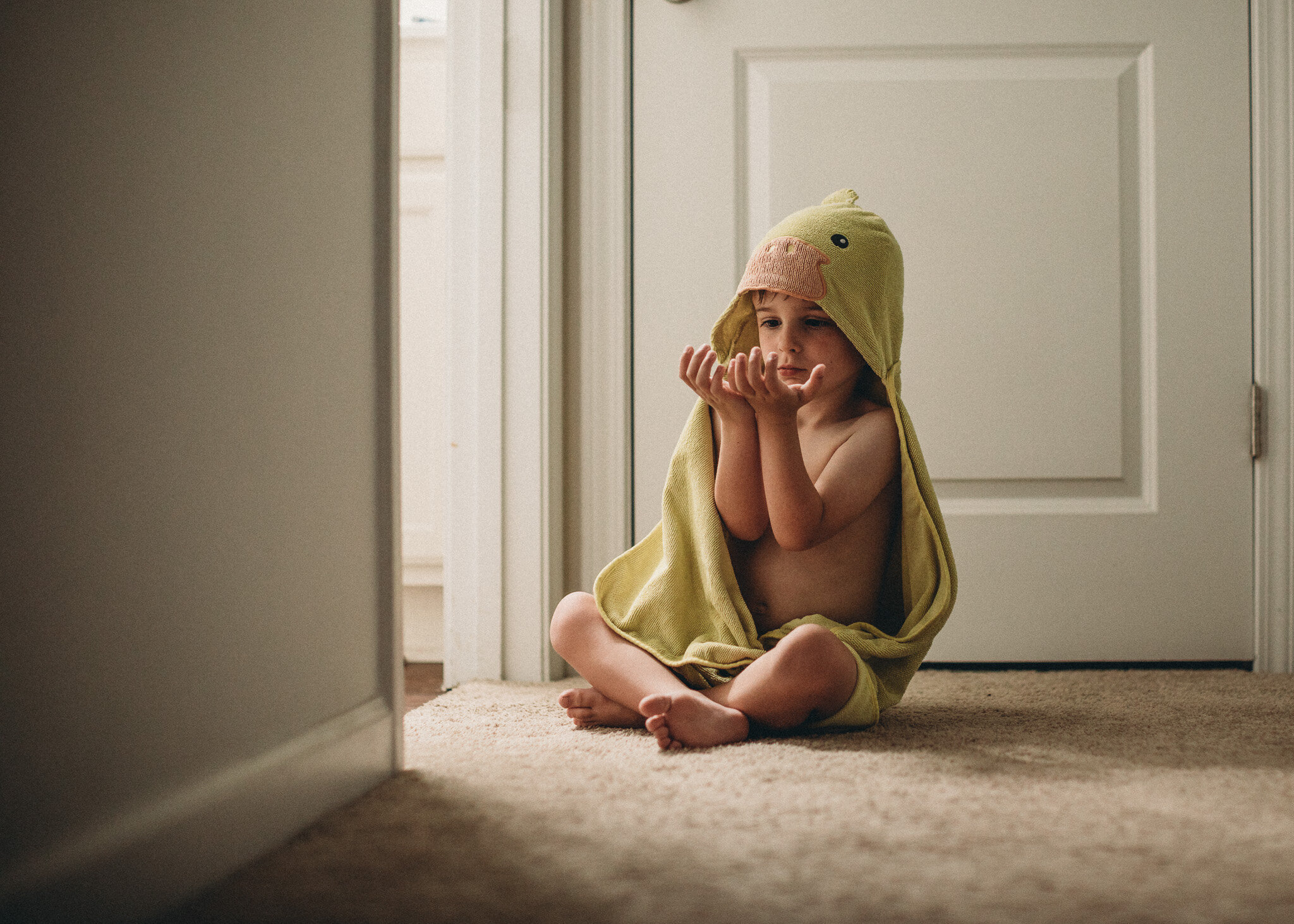 little boy in towel looking at hands
