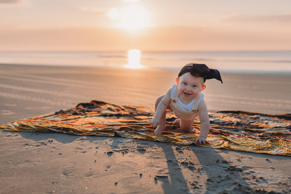 little baby girl crawling on beach 
