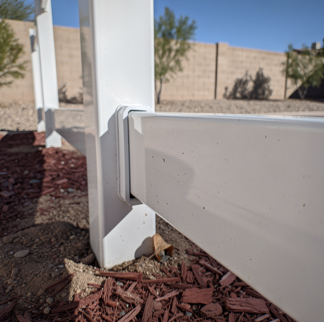 vinyl fence panels with warped sagging rail in summer heat