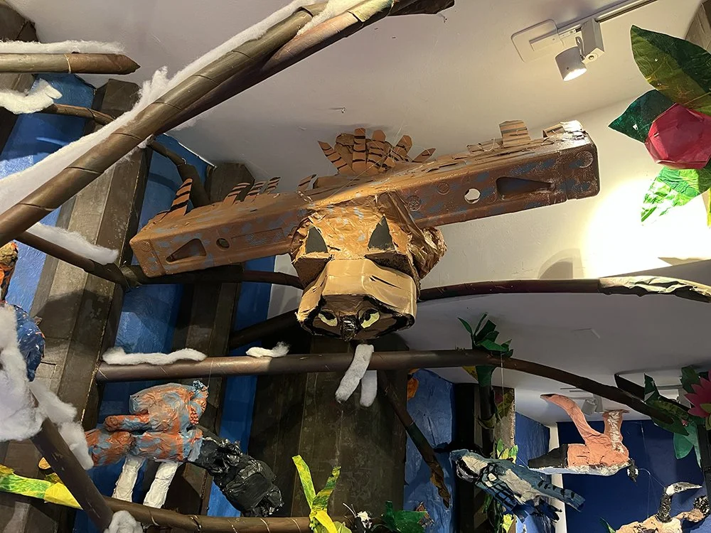   A great horned owl hovers above a blue bunting, a blue jay, and the rest of the winter forest.  