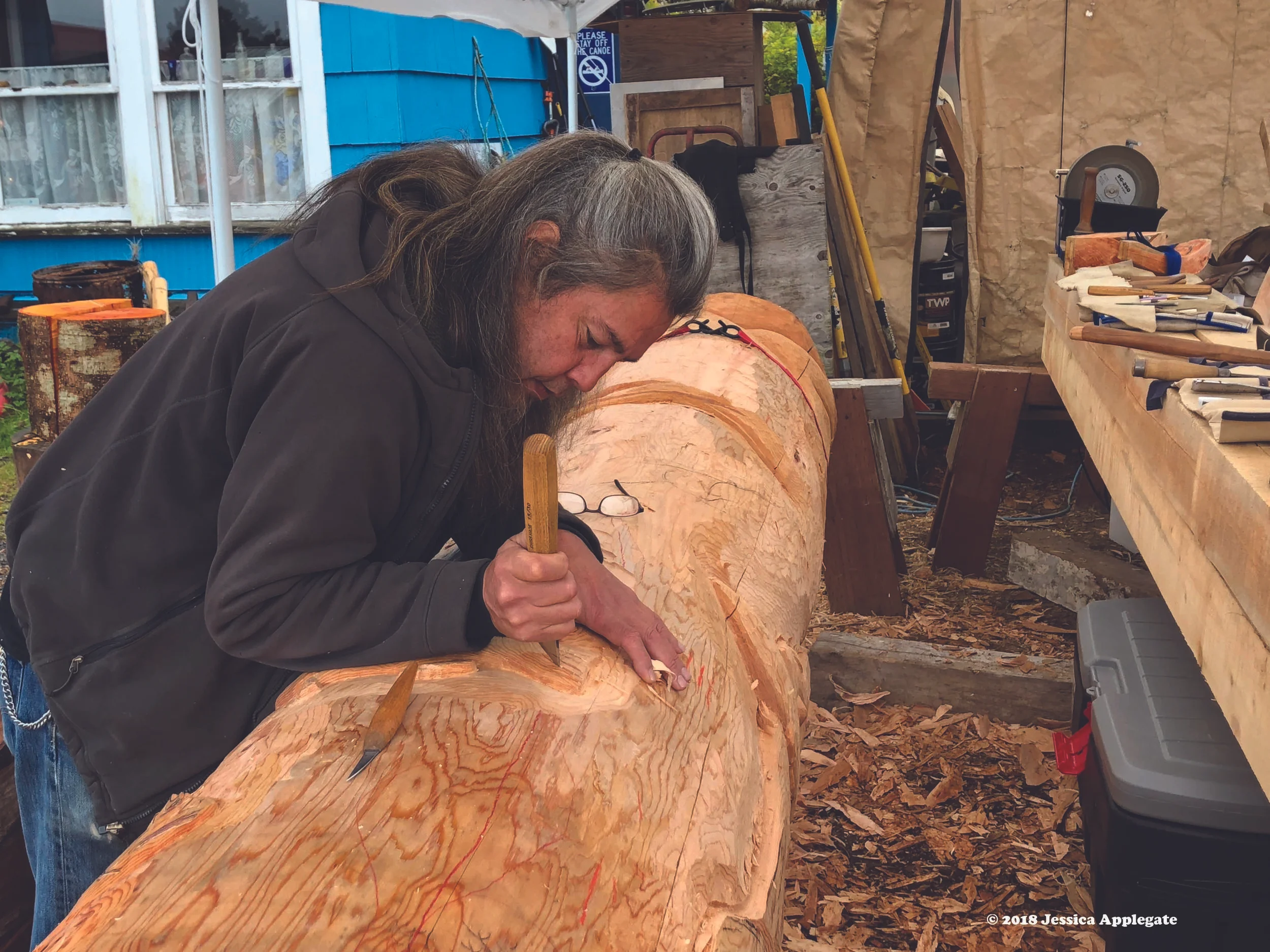 Tommy Joseph, a Tlingit artist in Sitka, carves a totem pole out of an Alaska yellow cedar log.
