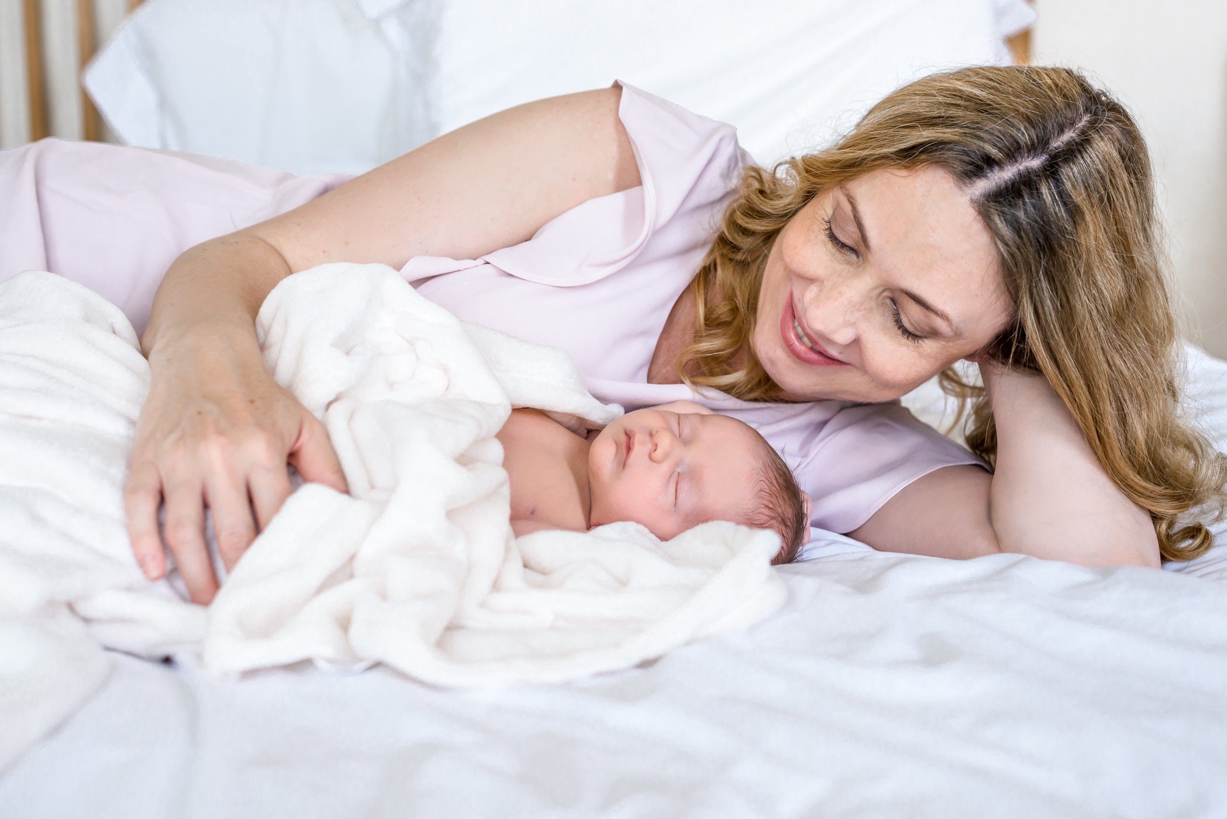 newborn mother and child natural on bed in colour.jpg