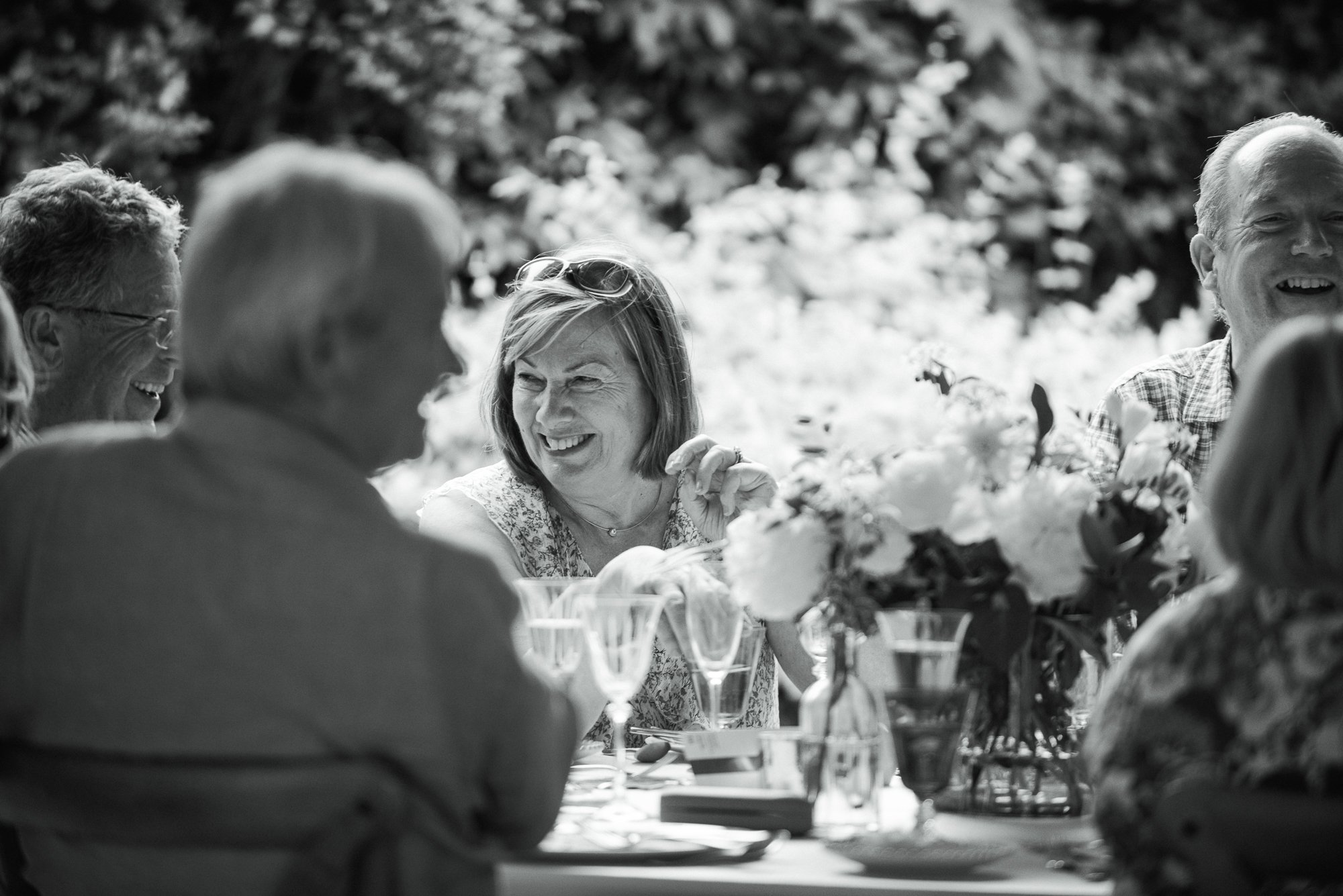 woman at a birthday party smiling with flowers in the foreground