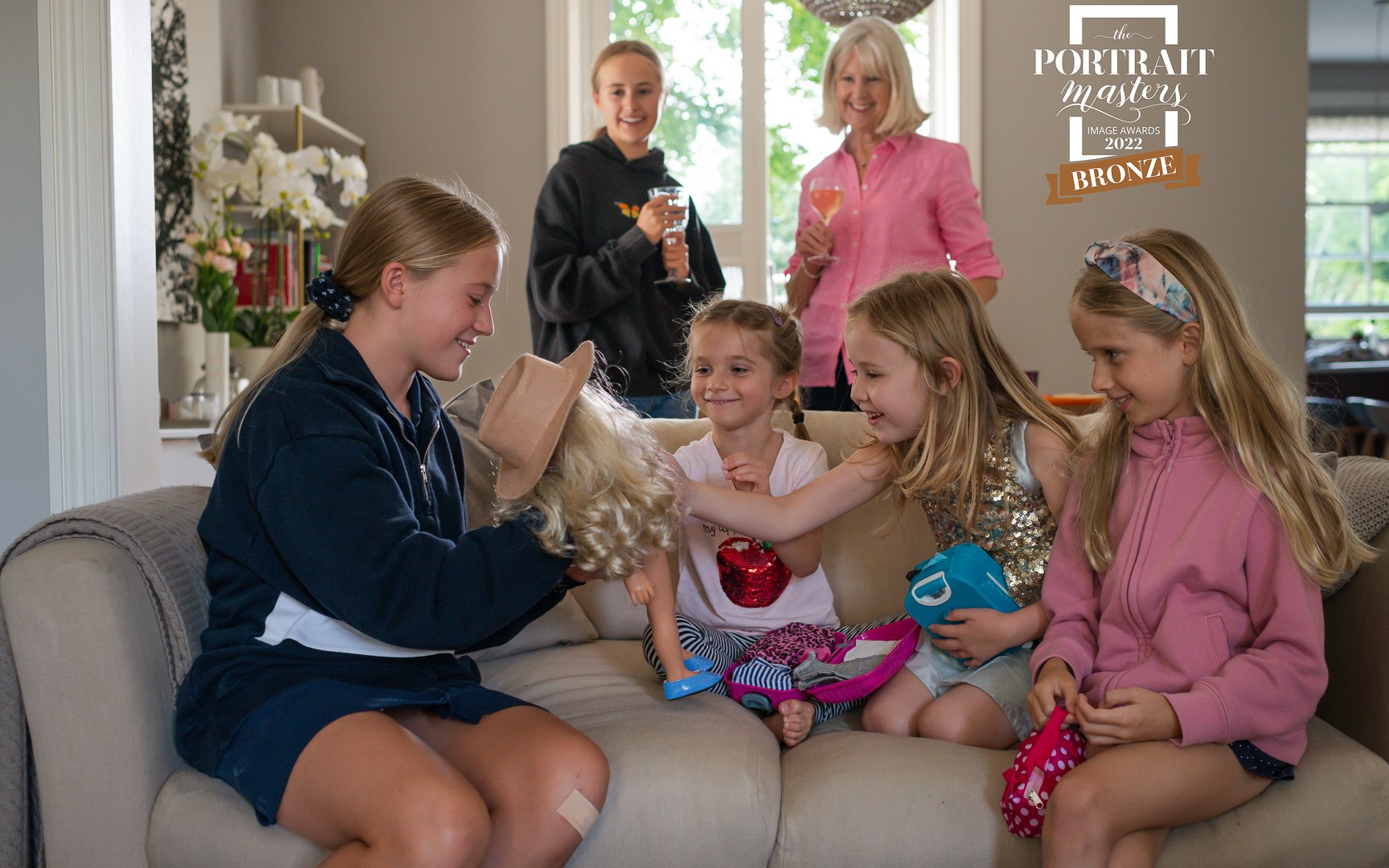 children playing with a doll with adults looking on