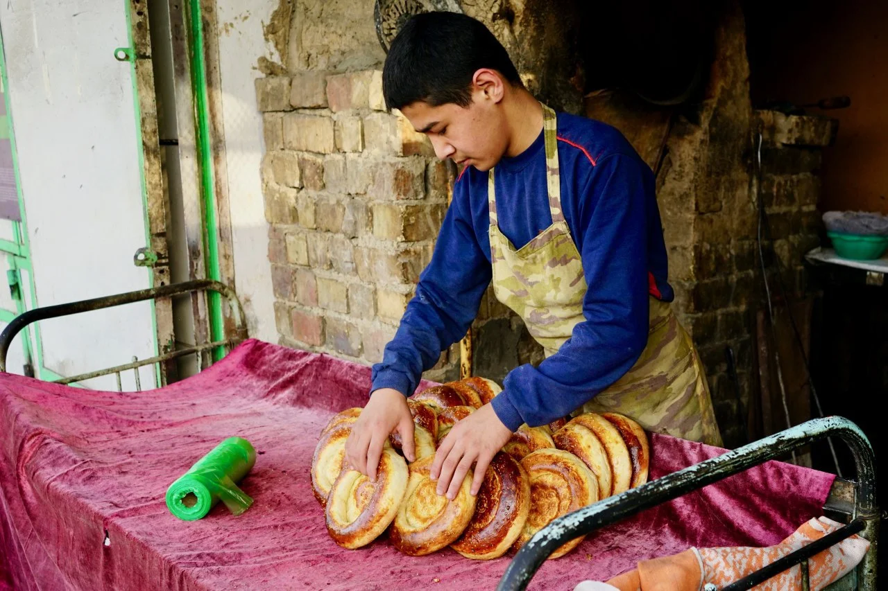 An Uzbek boy lays out bread for sale at a bakery in Osh, Kyrgyzstan