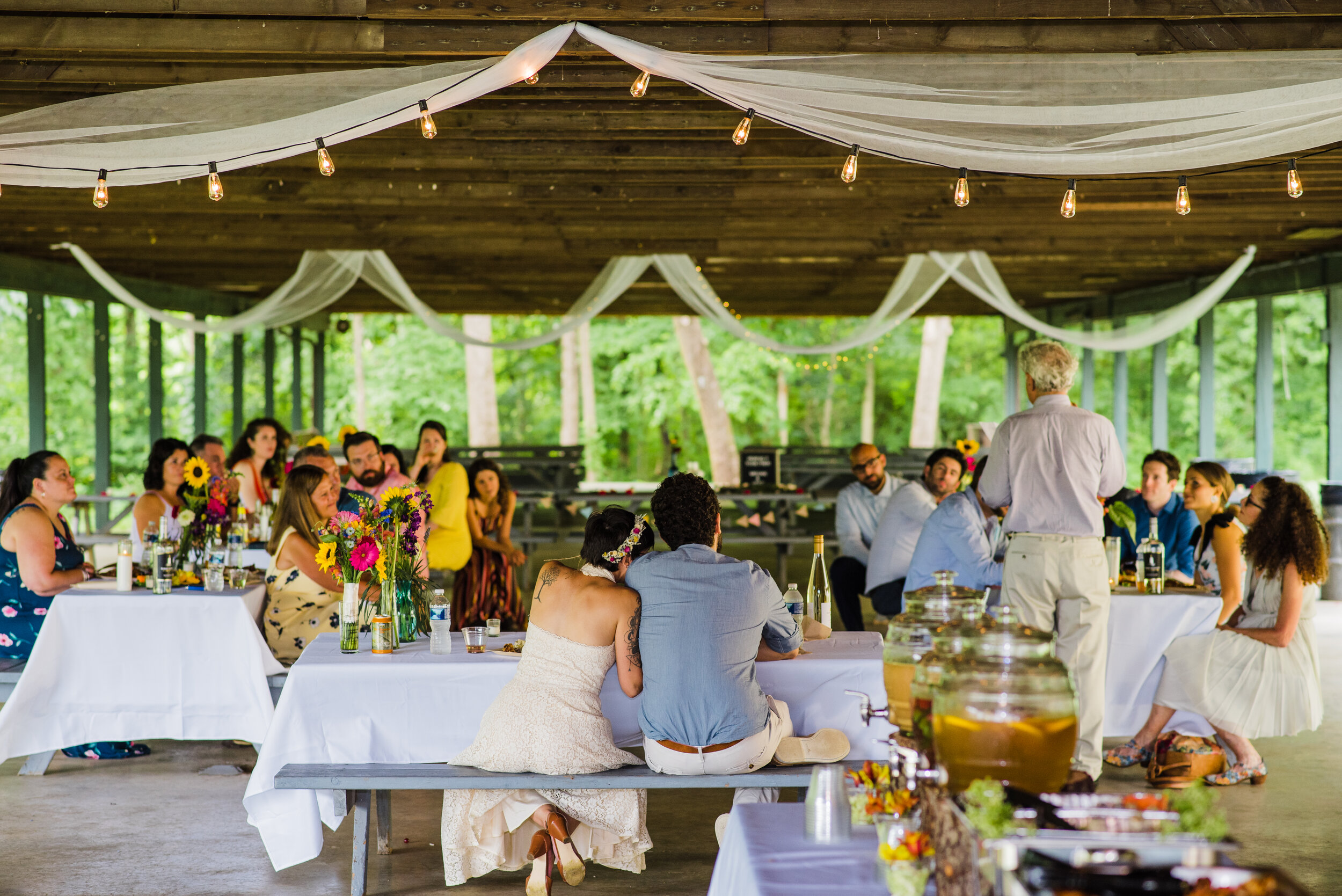 Intimate wedding reception under an outdoor picnic canopy.