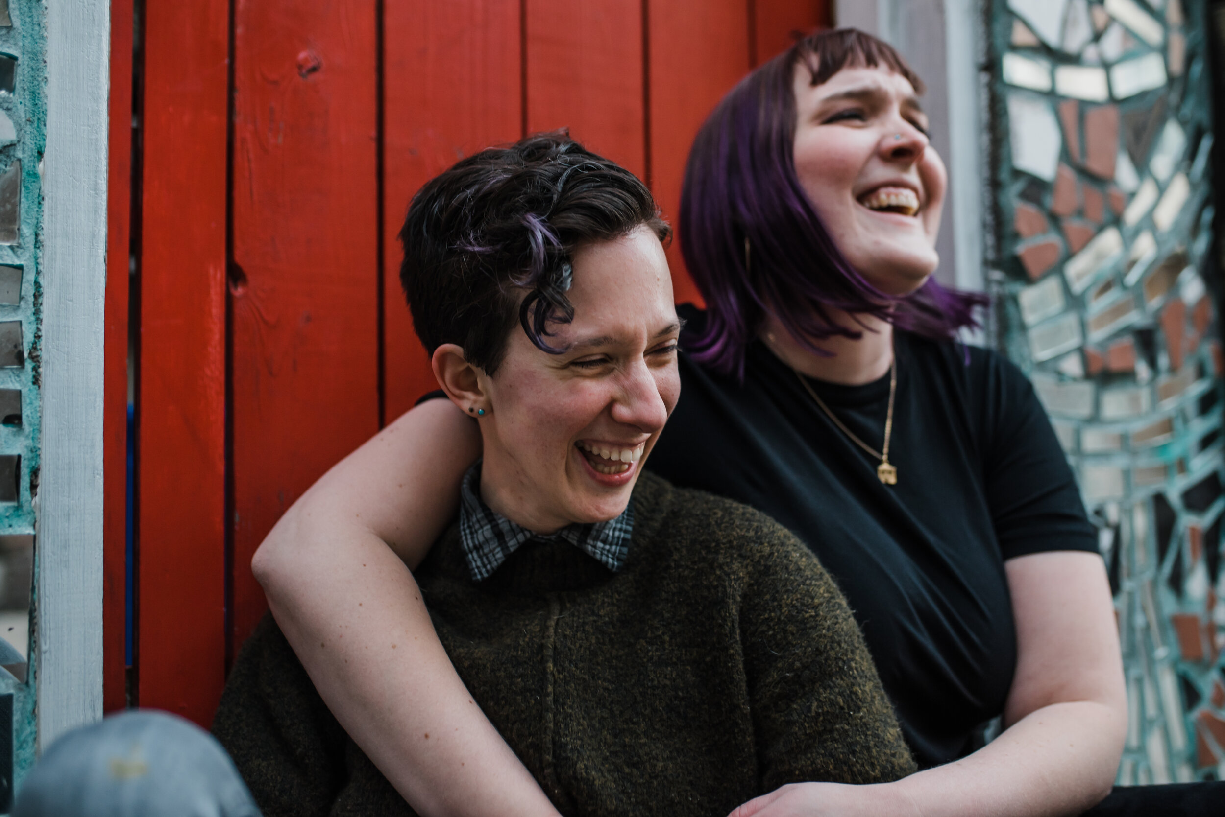 Philadelphia LGBTQ couple in front of a red door for their engagement photos.