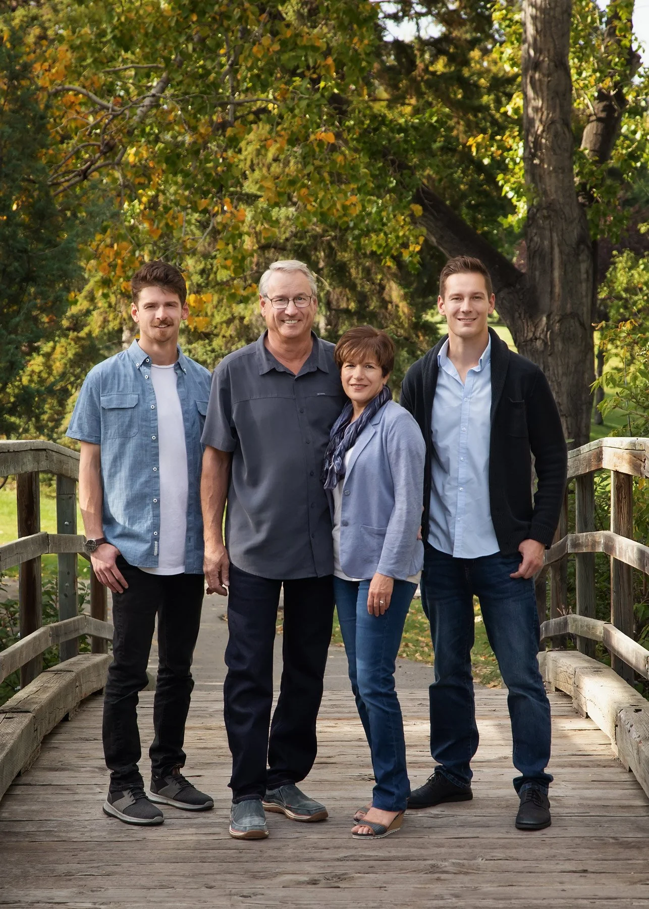 fall family photos on wooden foot bridge at confederation park calgary