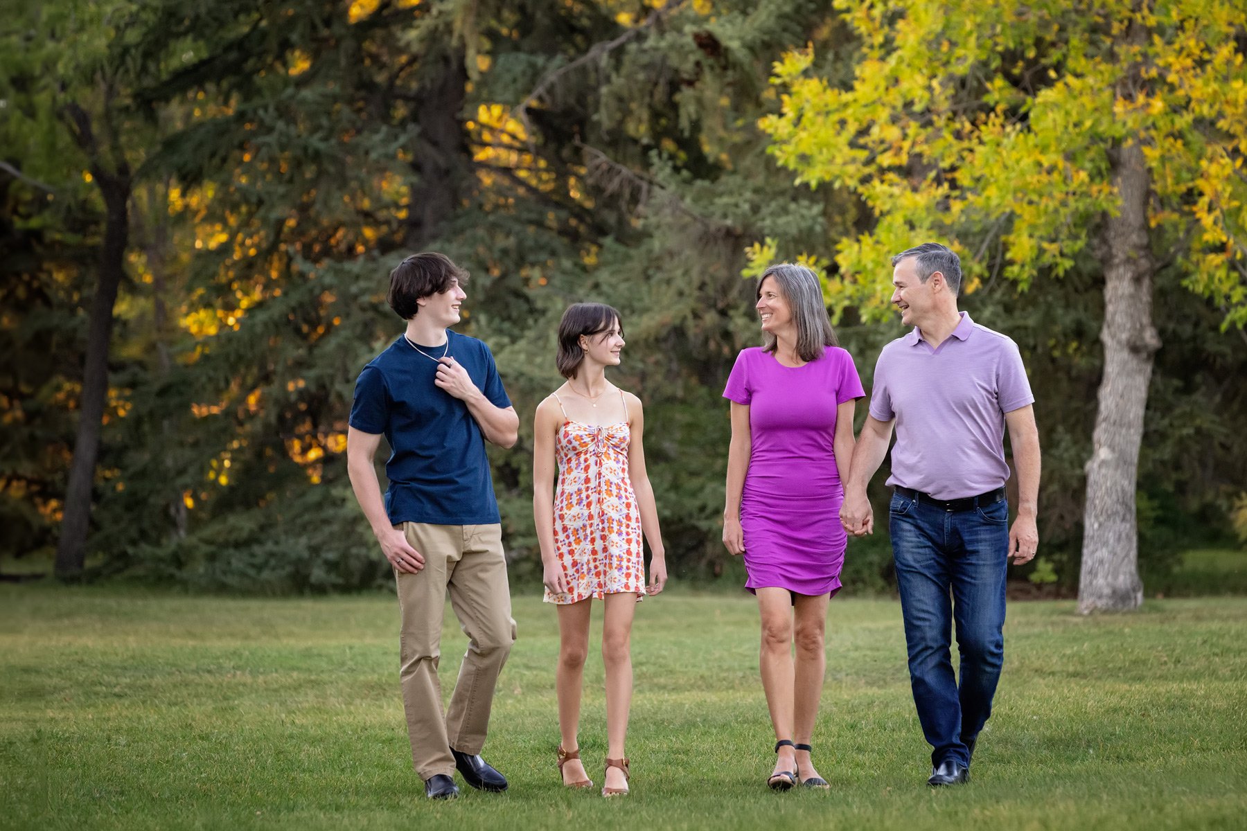 outdoor family portrait of family of four walking through Baker Park