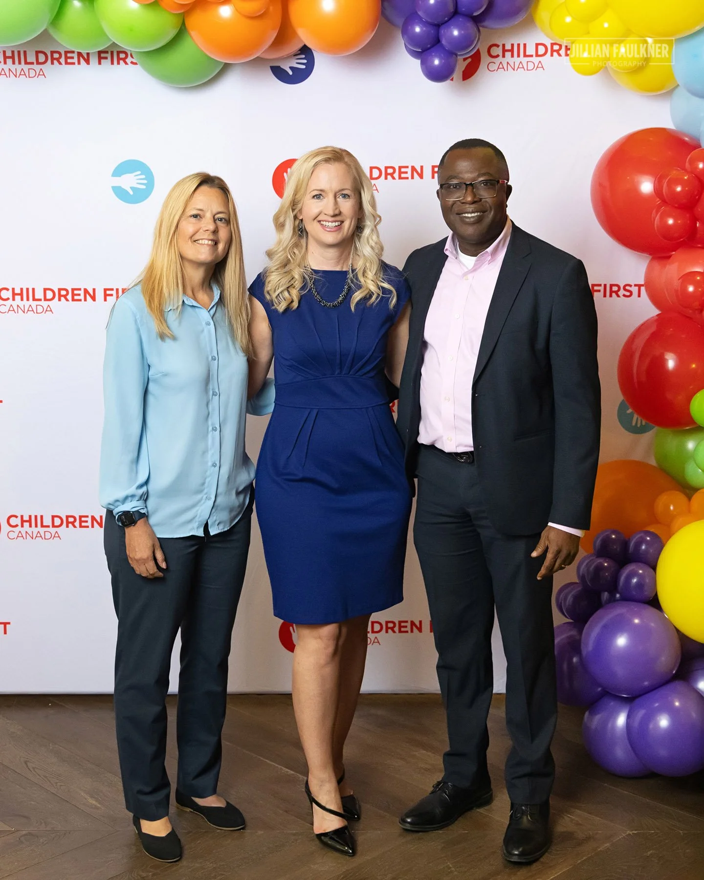 Executive team photographed at branded step and repeat at Children First Canada Calgary event