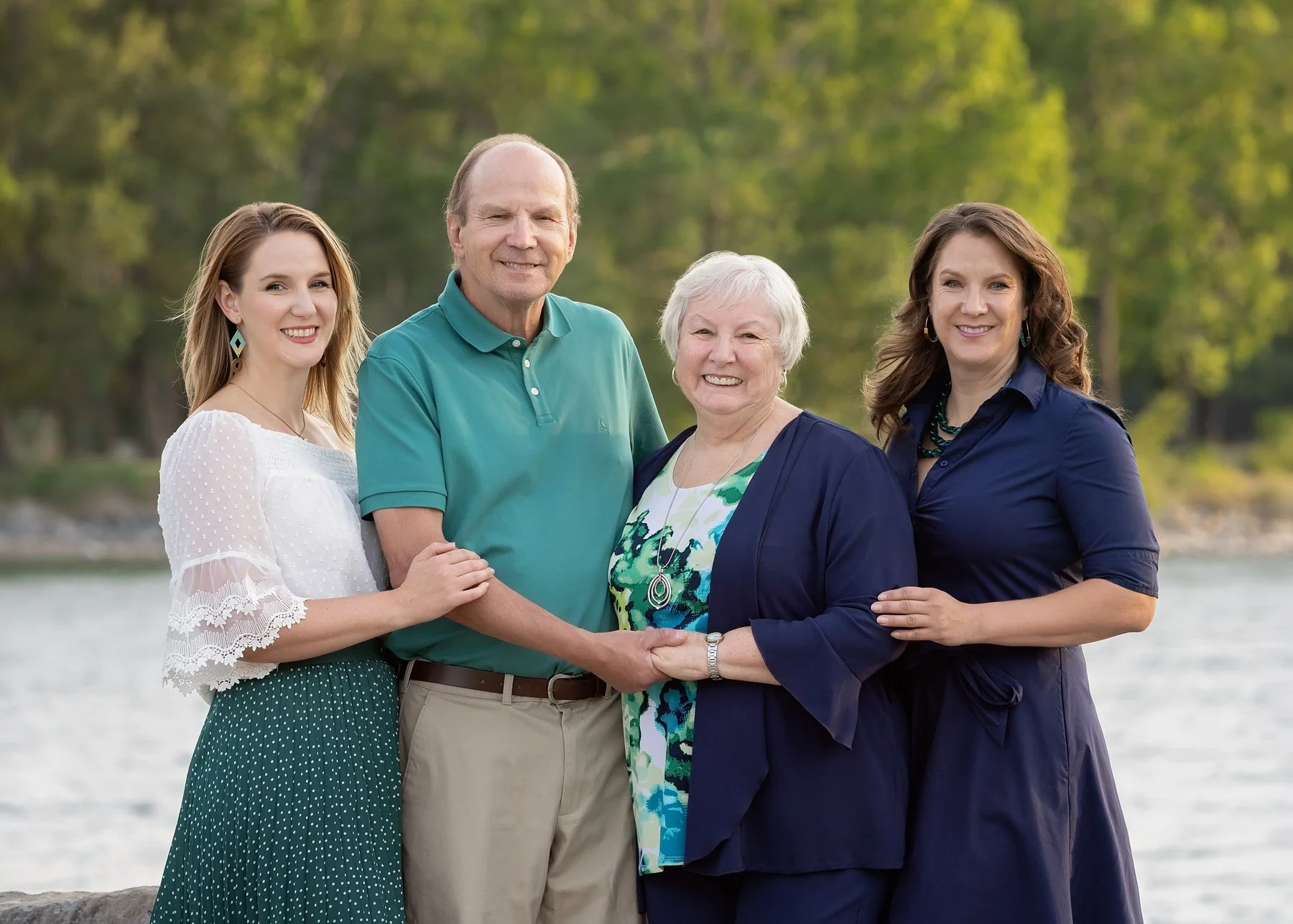 outdoor family photography of parents with two adult children overlooking the Bow River at Baker Park