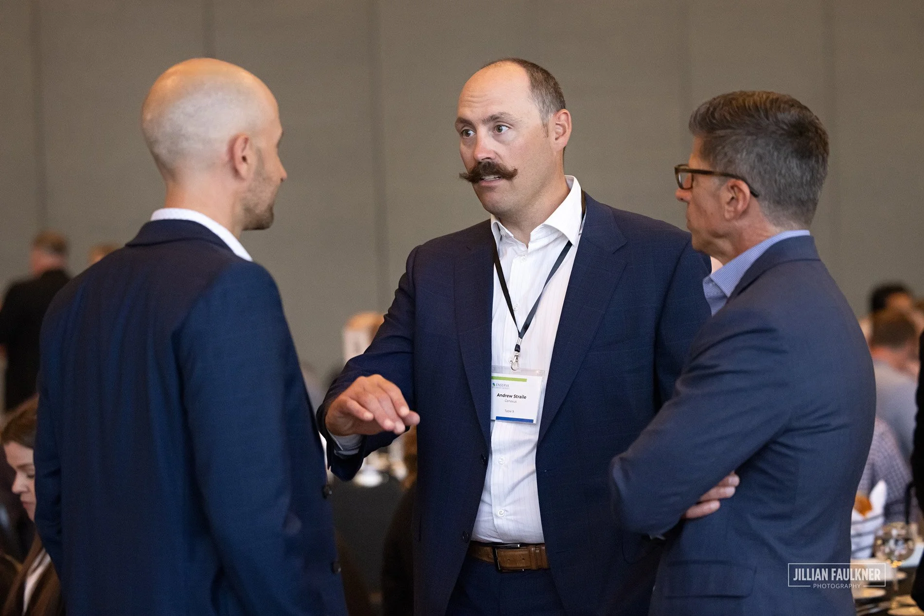 High quality candid photography of networking moments between Western Canadian energy leaders at Enserva Calgary summit captured by professional event photographer