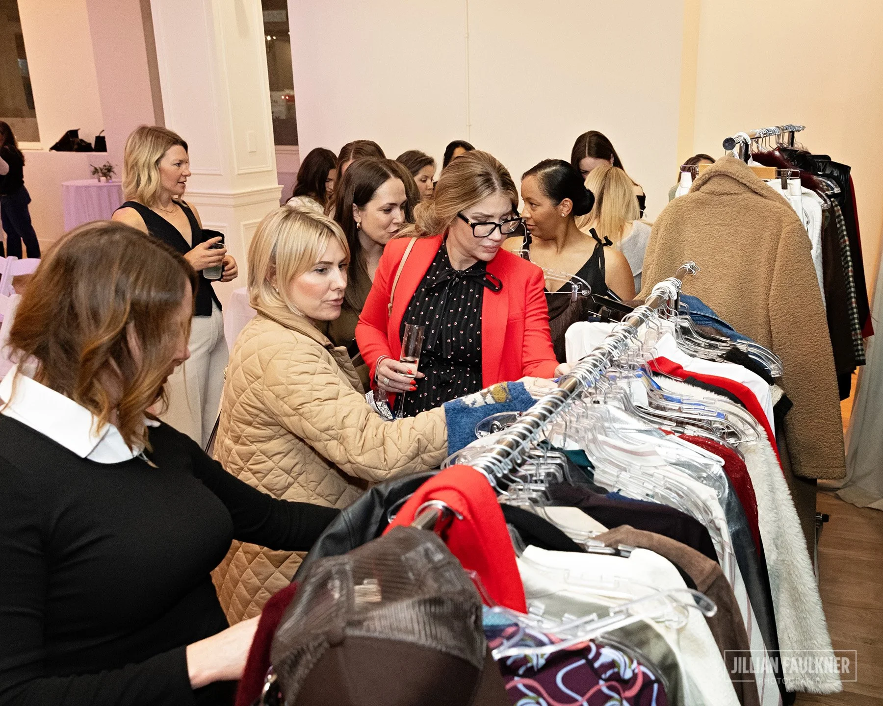 Calgary corporate and fashion event photographer captures guests selecting luxury fall and winter outerwear