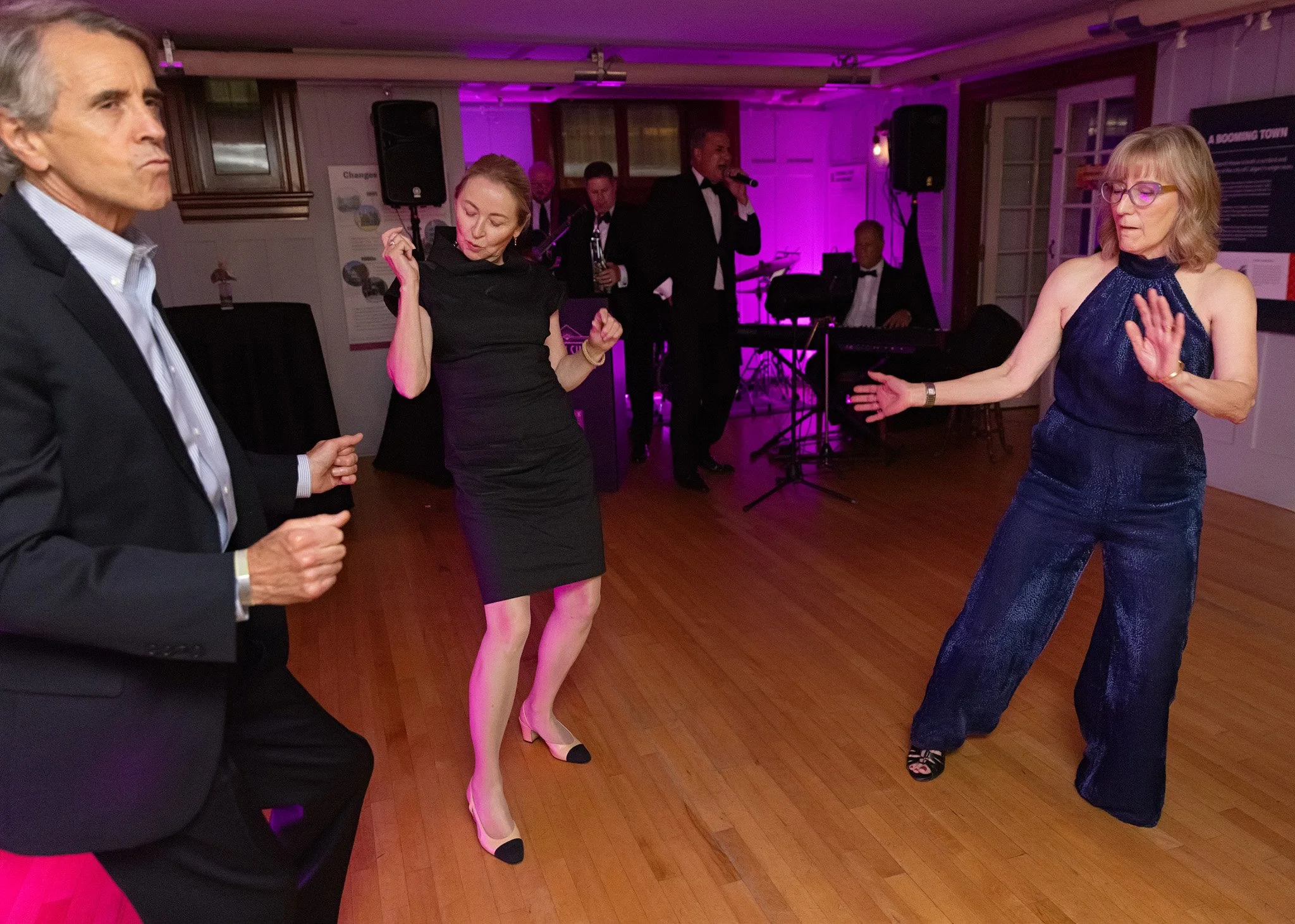 Professional candid event photography capturing movement of guests dancing together at Calgary Lougheed House 20th anniversary celebration