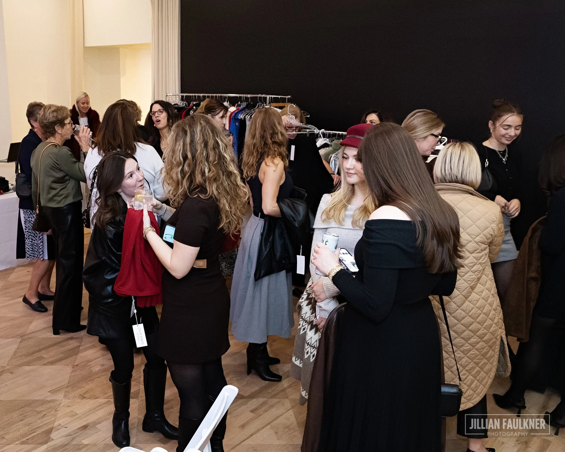 High quality Calgary Alberta event photography of elegantly dressed guests engaging with Crystal McKenzie's curated designer collection during the exclusive on-site shopping experience