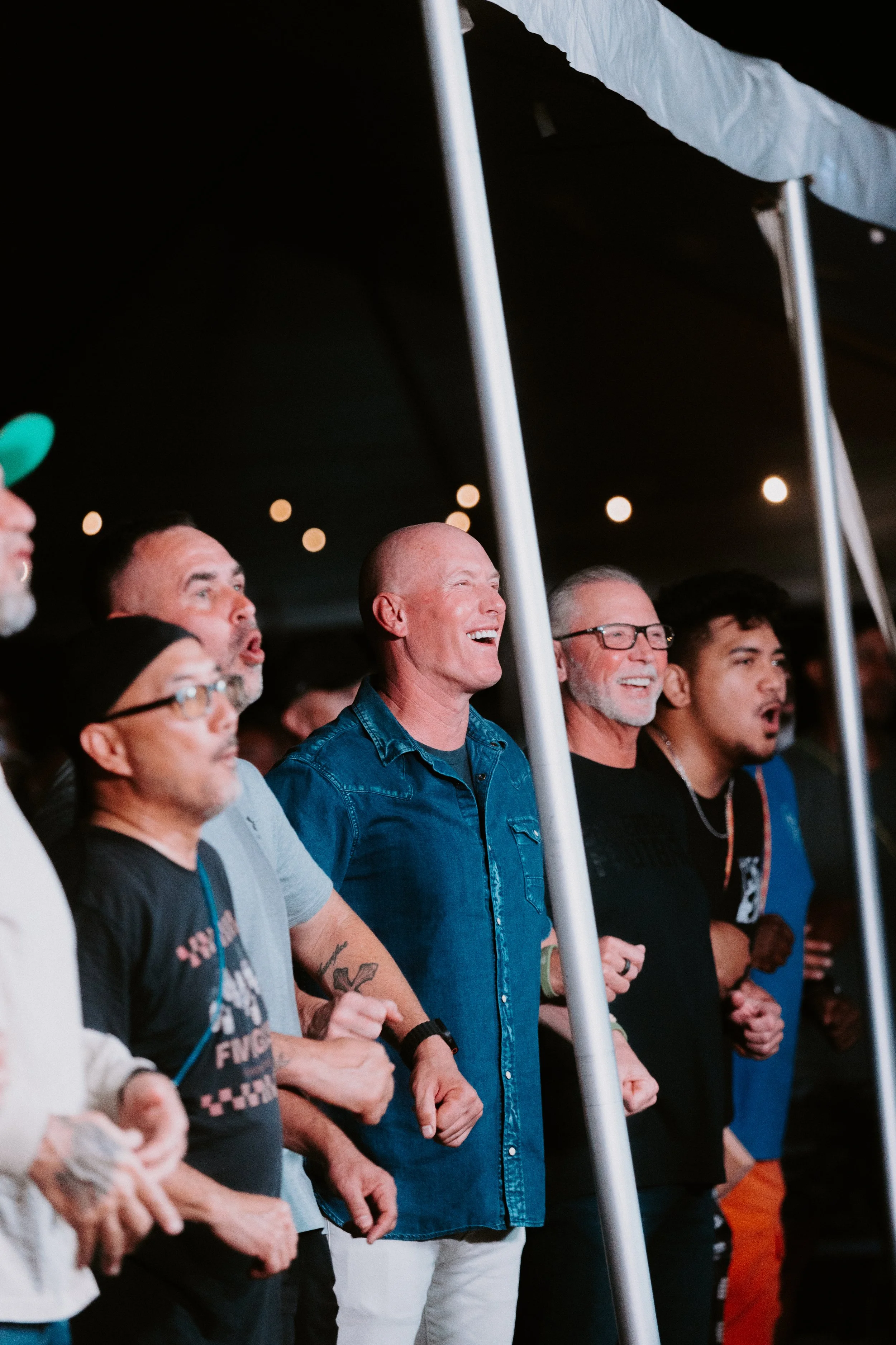 Men standing together and smiling during Kingdom Man Camp 2025.