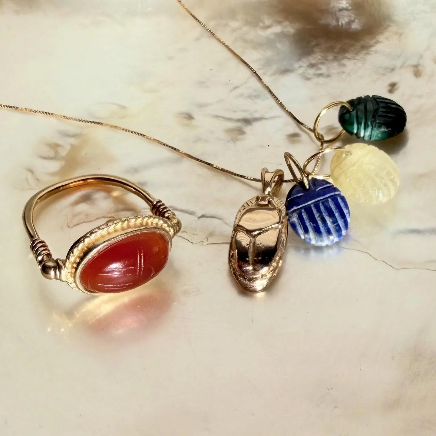 One can never have enough scarab beetles 🪲 The little carved gemstone charms with 14K bales in malachite, rutilated citrine &amp; lapis lazuli are not online, 125 each shipped. Tap post to shop or kink in bio for carnelian ring &amp; 14K charm neckl