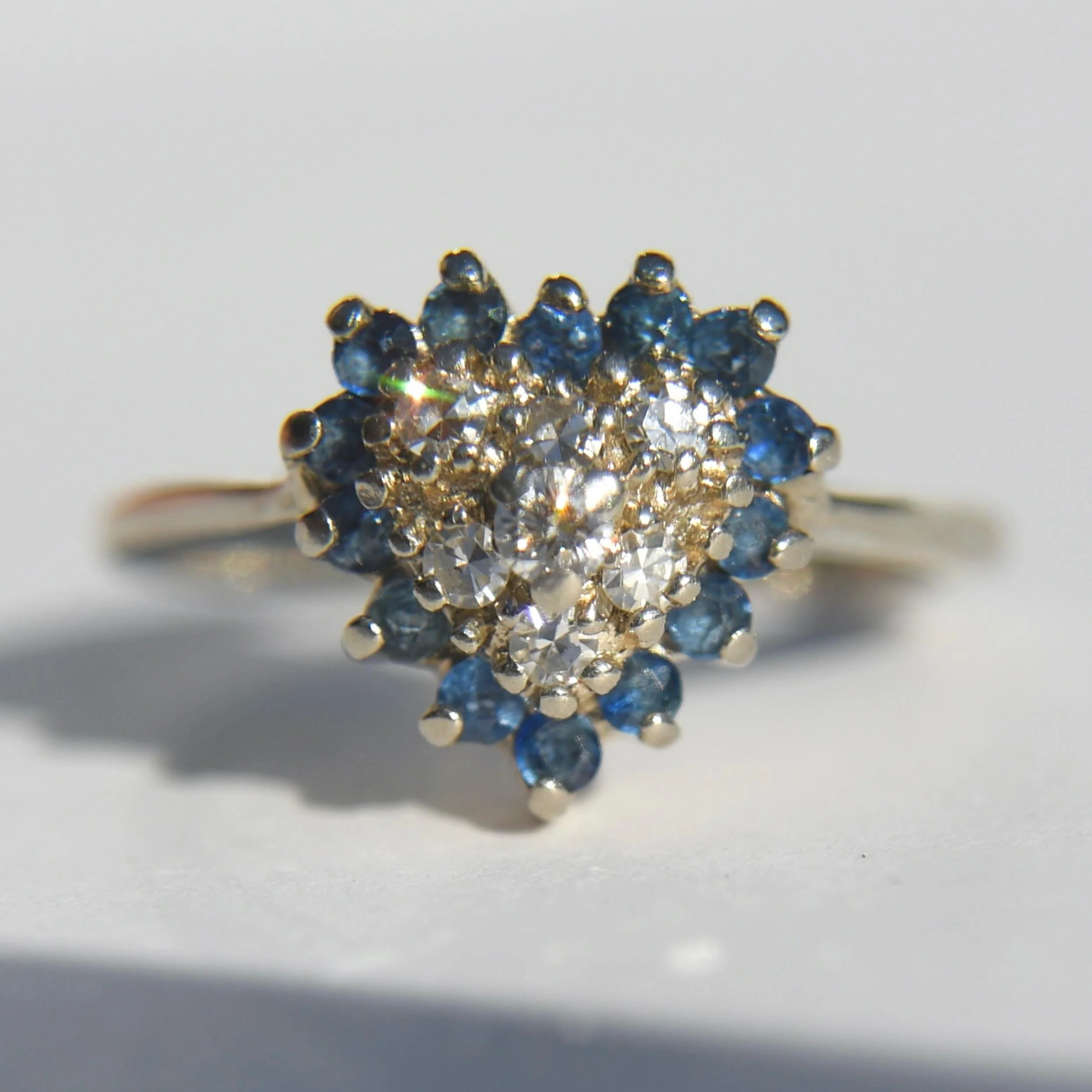 In love with this glittering vintage 1980s 14K WG diamond sapphire cluster halo! Online, tap post to shop or link in bio 💙💎 #sapphirering #diamondheartring #vintagediamondring
