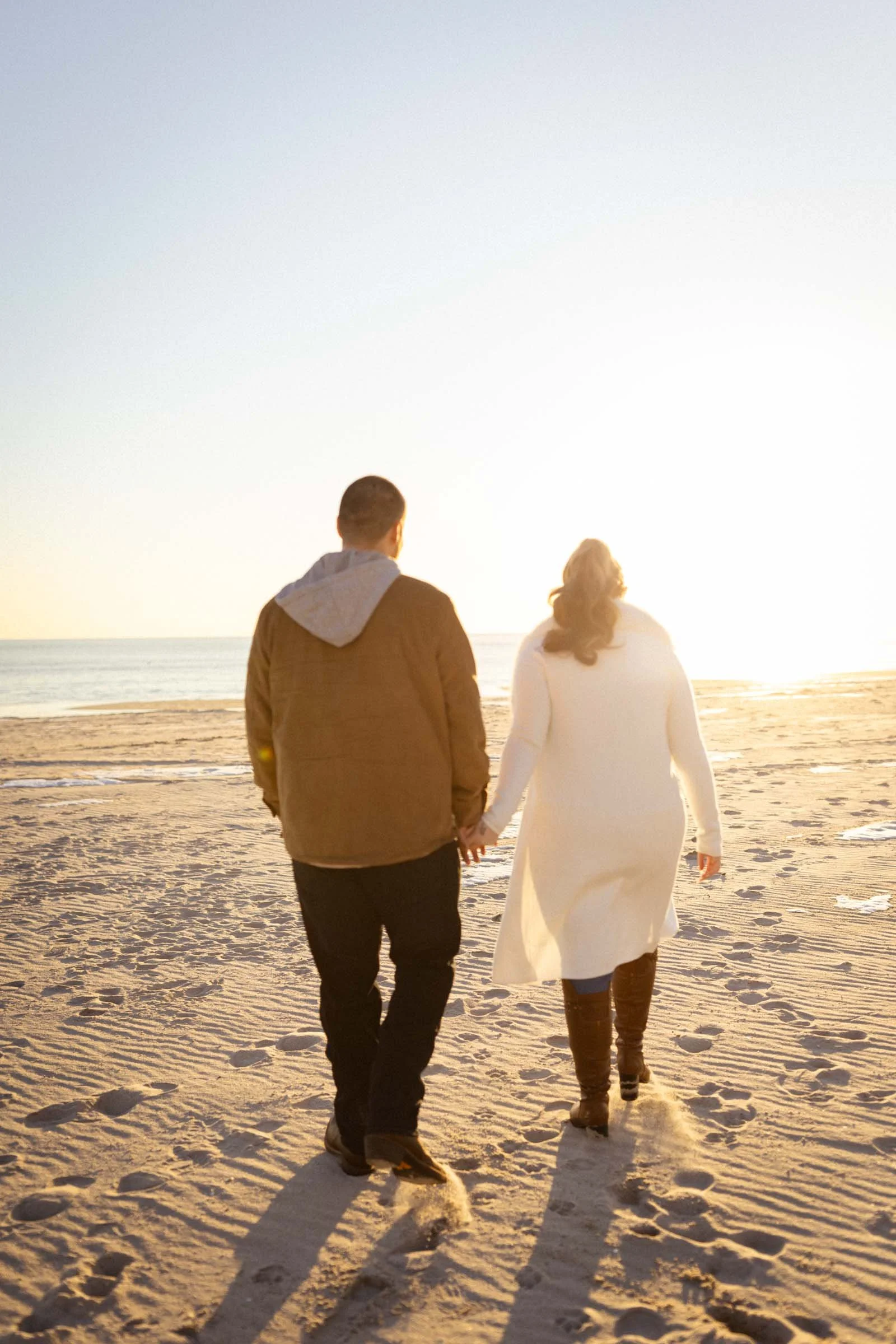  Couple walking on beach at sunset in Long Beach, NY.  