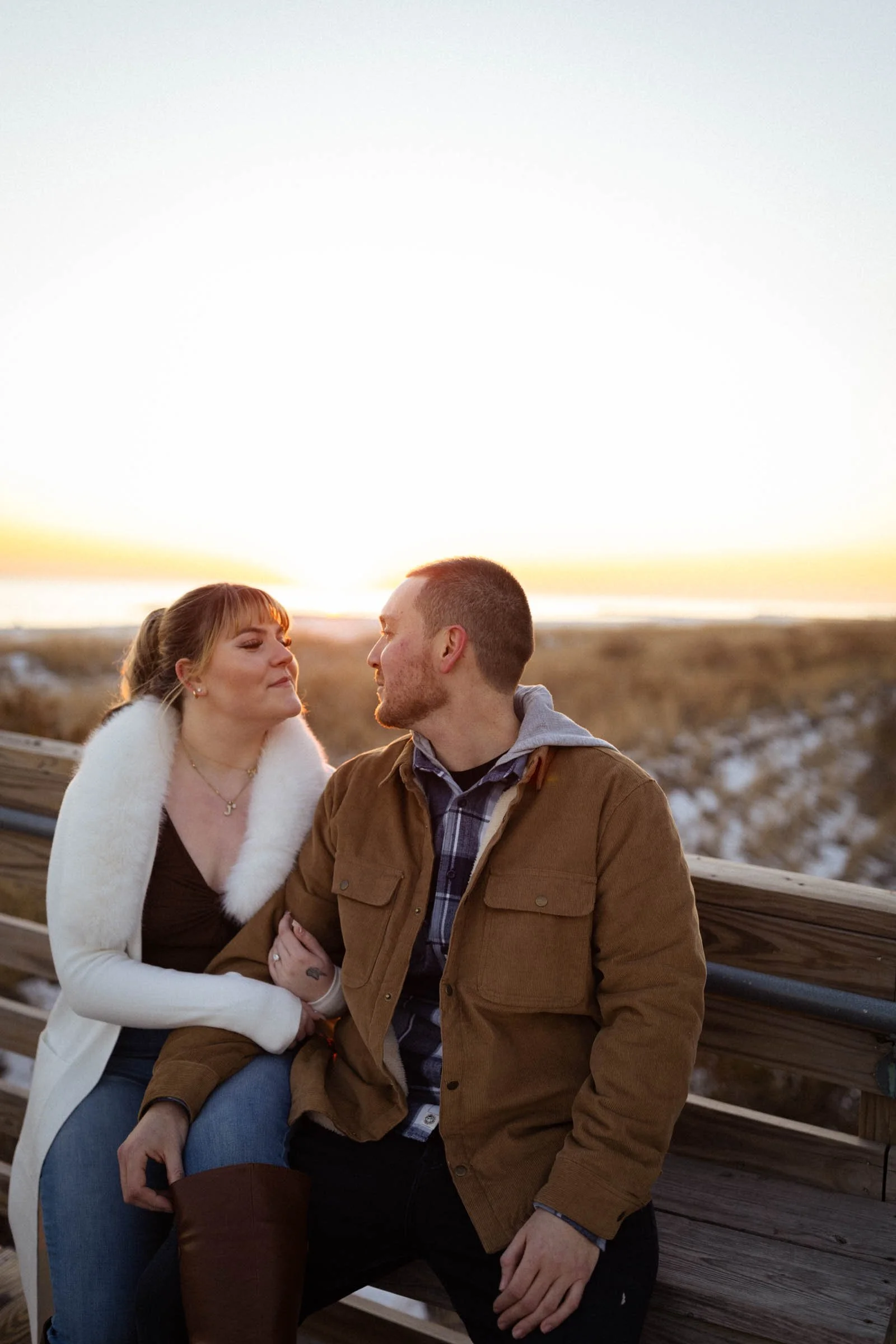  couple sitting on bridge at sunset 