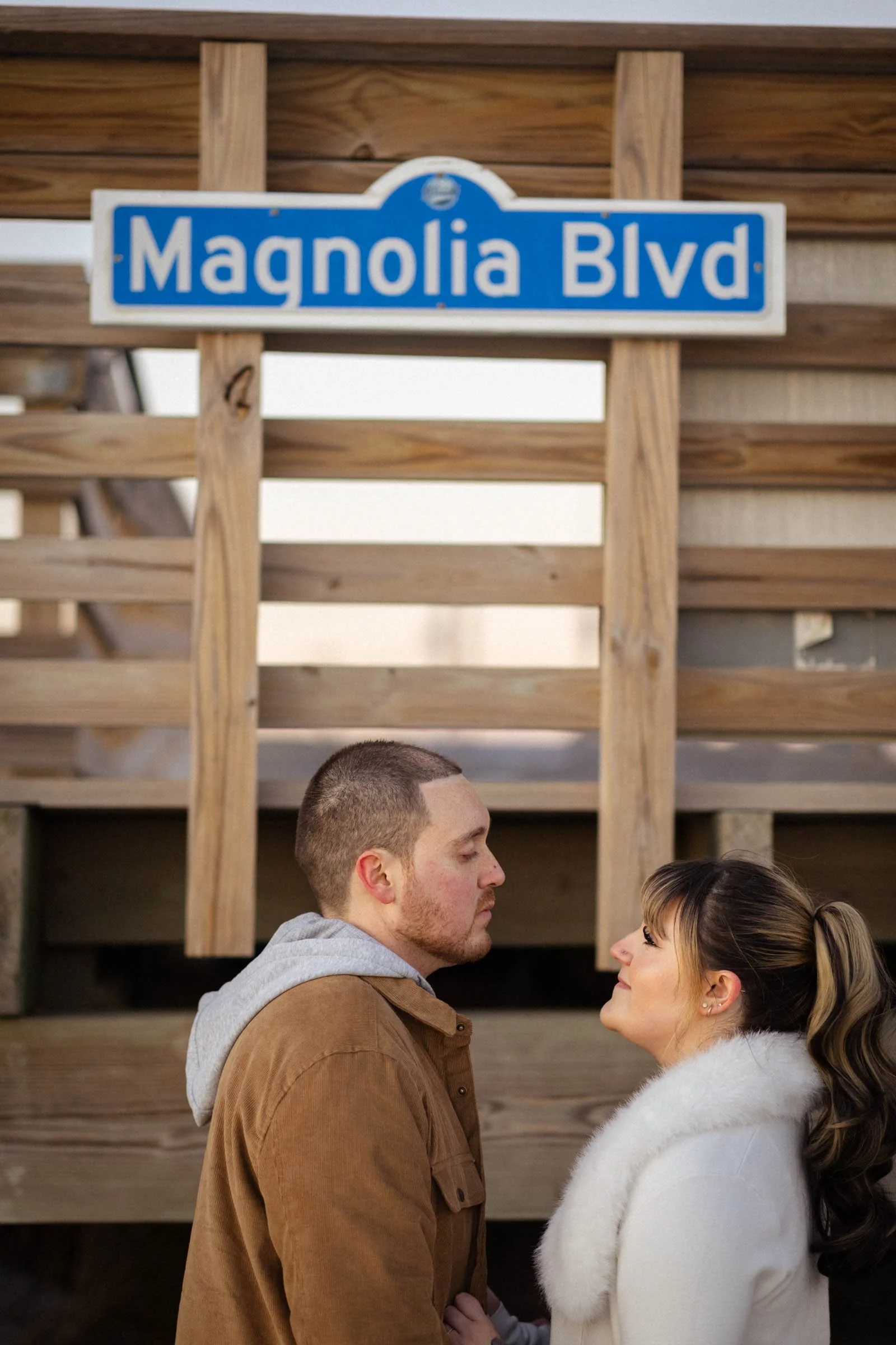  Couple looking at each other with boardwalk sign above them 
