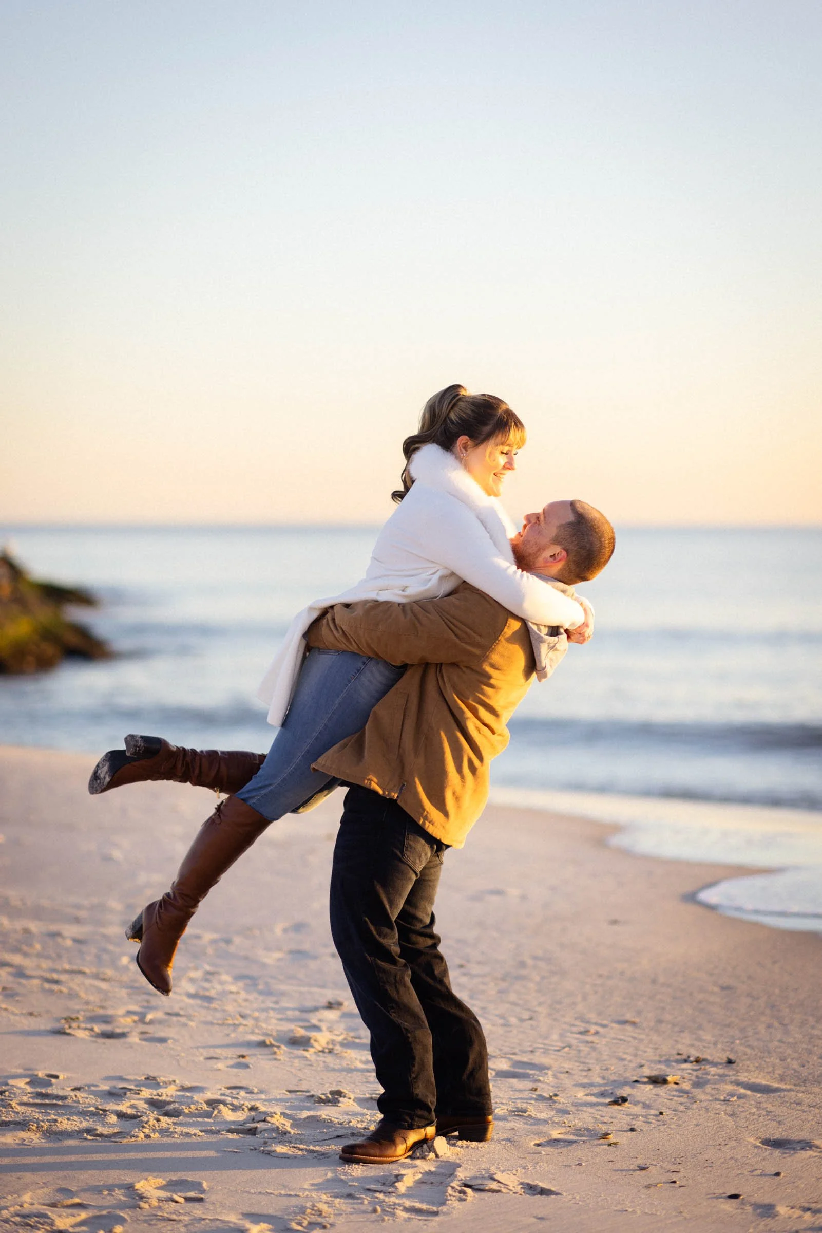  Man lifting woman on beach 