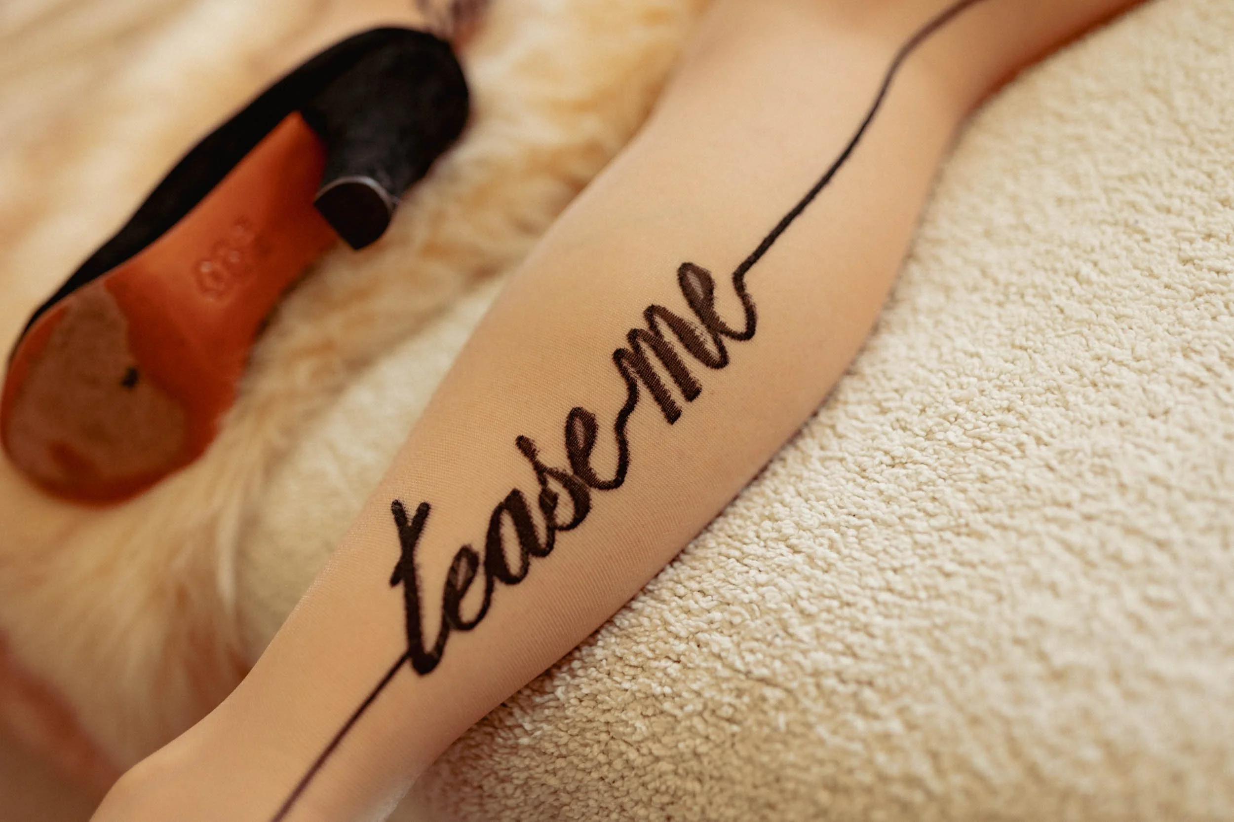 stockings with the writing "tease me" on them