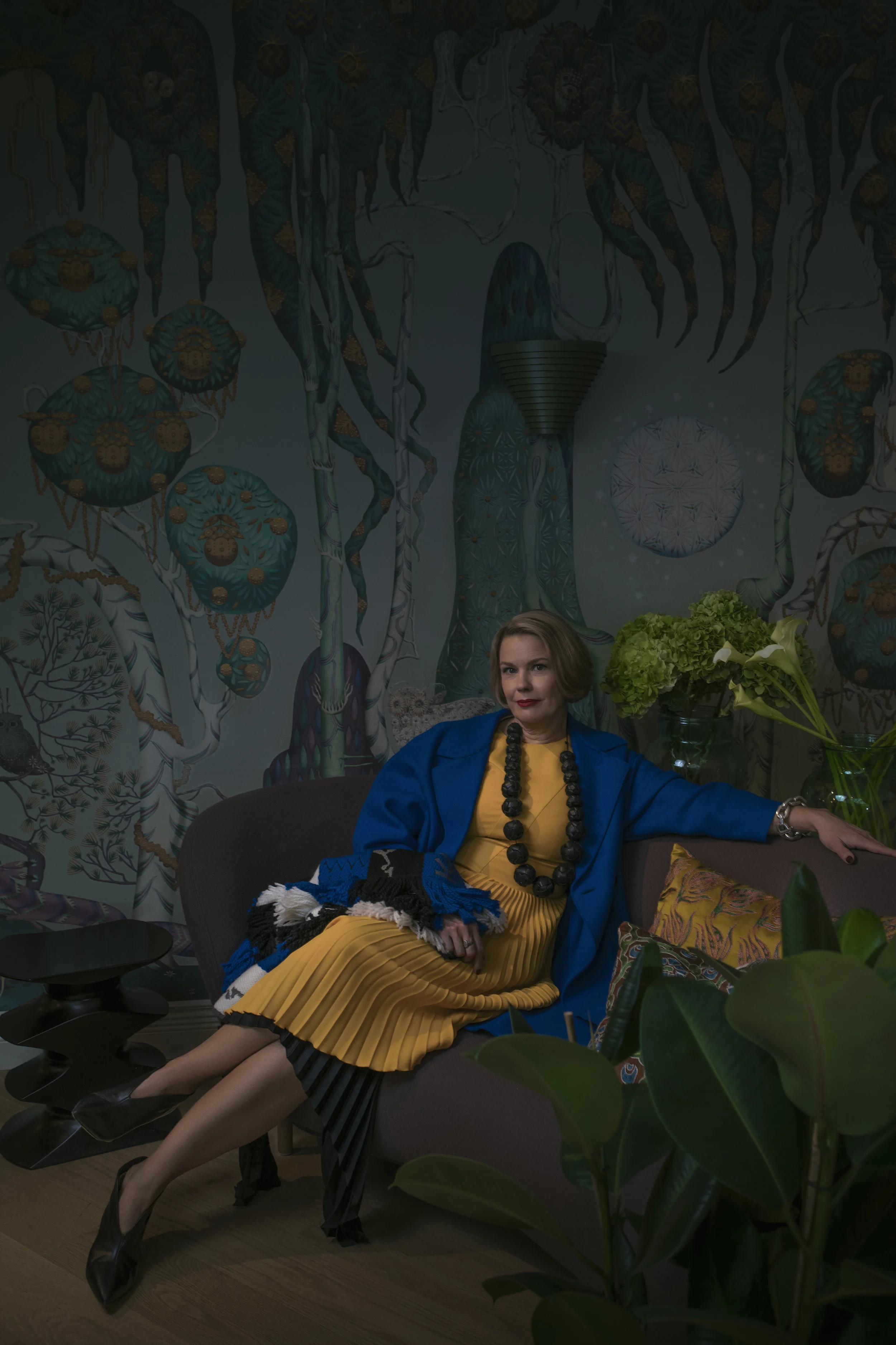 Johannan hihaton keltainen mekko jossa on osittain pliseerattu helma 449 e, Hugo Boss , Stockmann ja mekon alla on toinen musta pliseerattu hame, jonka helma on epätasainen 245 e, by Malene Birger , myös Stockmann . Sähkönsininen vuoreton villakangastakki 480 e, Harris Wharf London sekä iso hapsullinen kaulaliina, jossa näkyvät logot, niin kuin tänä syksynä kuuluu ollakkin 319, Kenzo , molemmat My o My . Kaulakoru ja kengät Johannan omat.