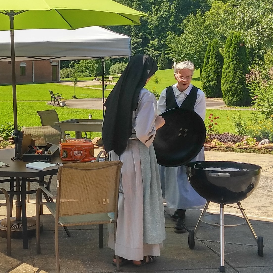 Christie giving Sr. Lucia Marie expert pointers on grilling hamburgers.